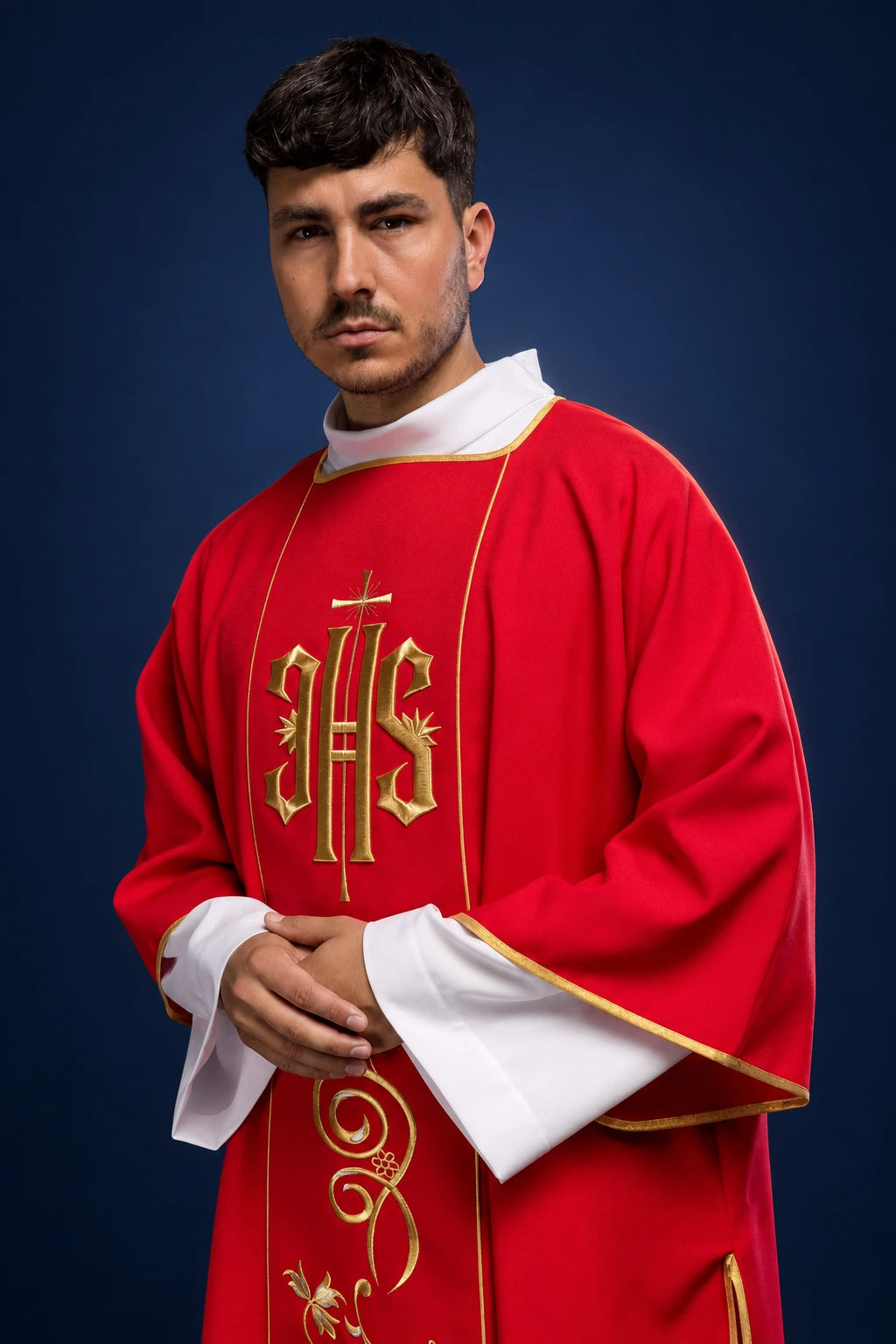 Front view of a red dalmatic with gold IHS embroidery and white cuffs trimmed in gold