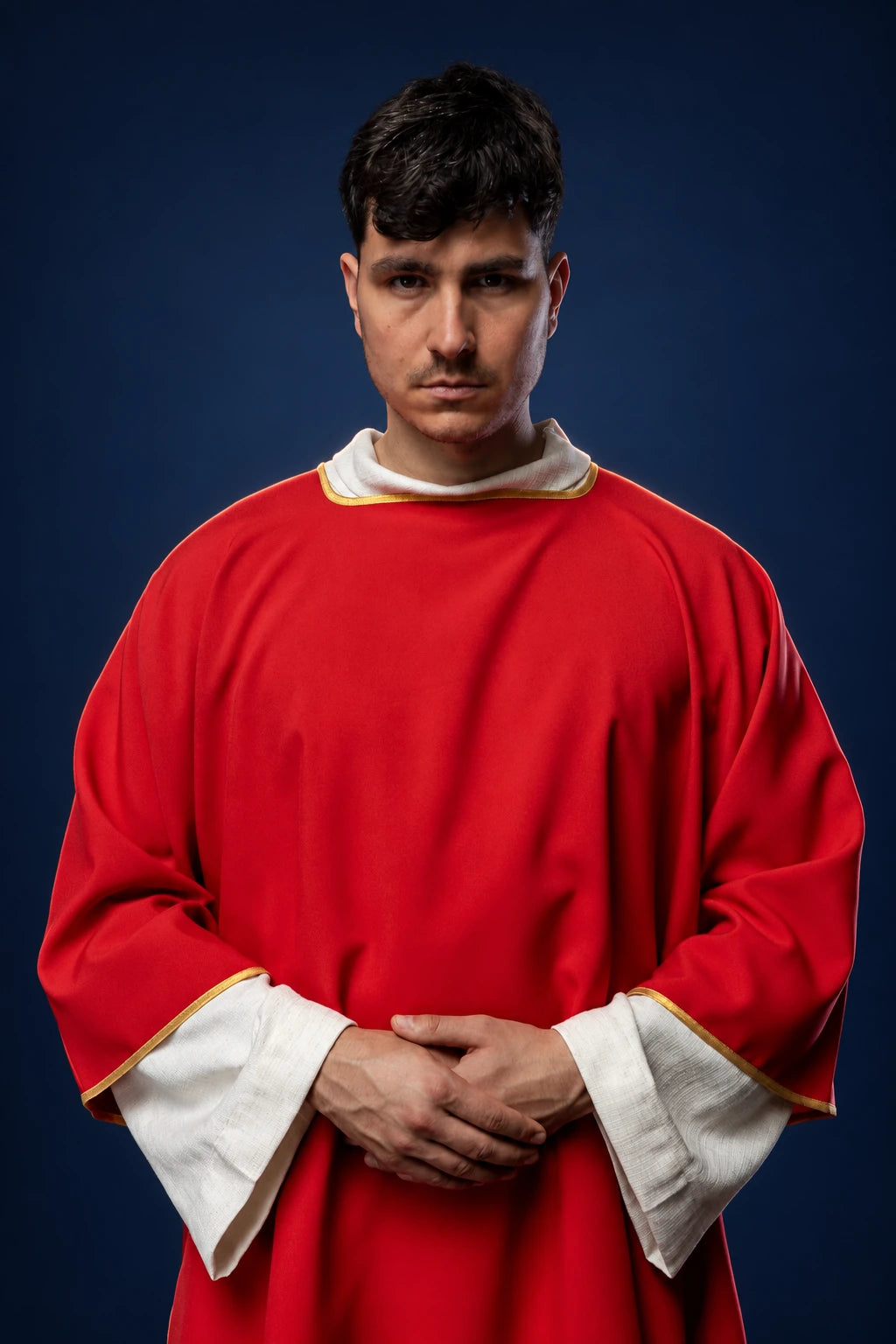 Front view of a red dalmatic with gold trim and white sleeve cuffs