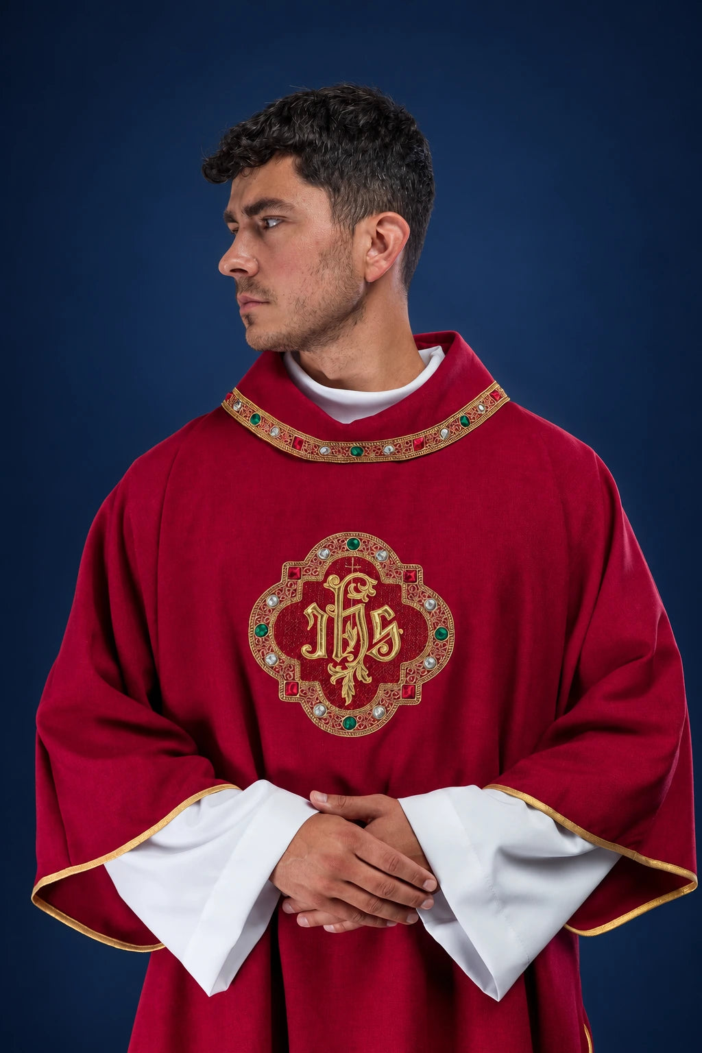 Front view of a red dalmatic with gold-trimmed collar and IHS emblem on the chest