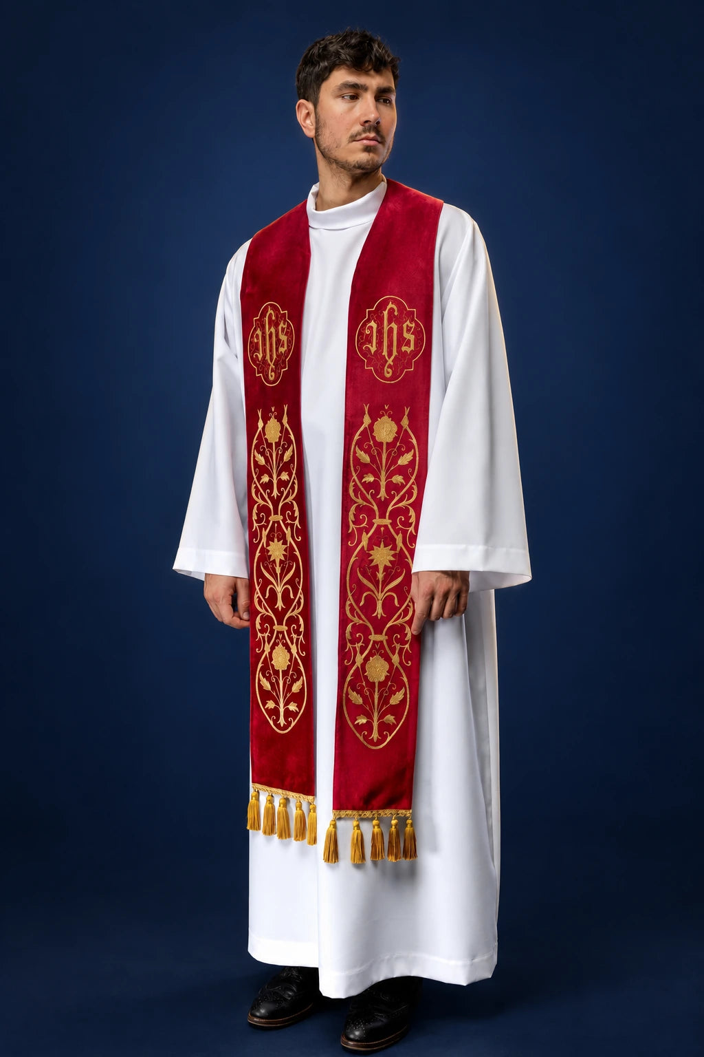 Front view of a red one-sided stole with gold IHS and vine embroidery, worn over a white alb