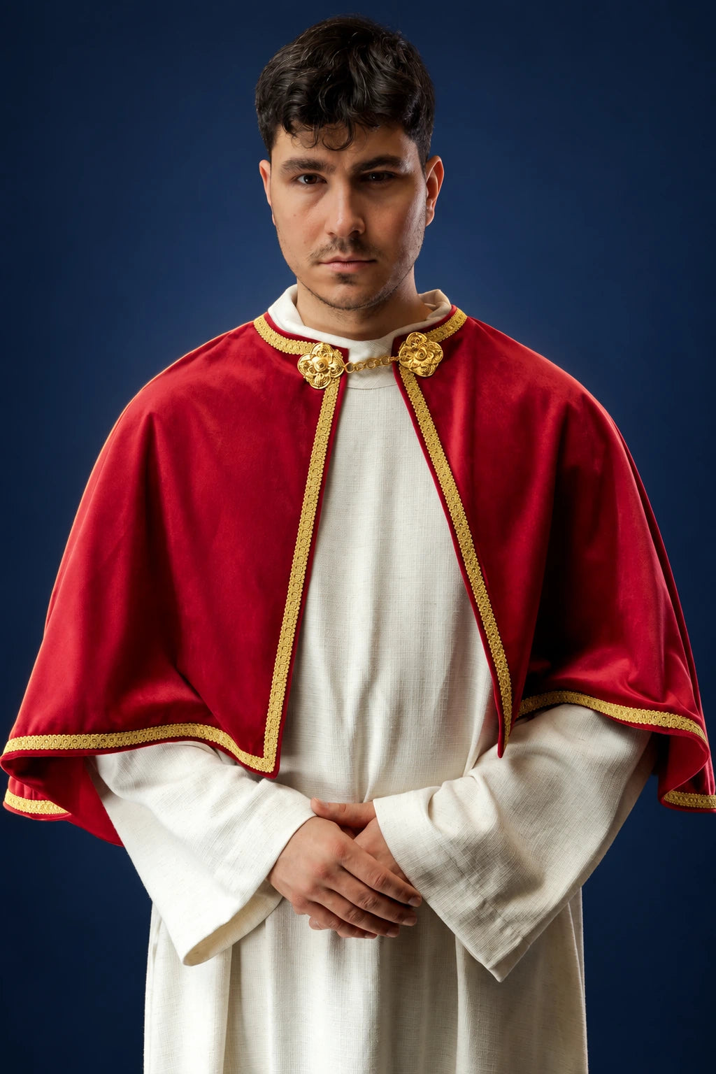 Front view of a red velvet altar server cape with gold trim and clasp, draping over the shoulders