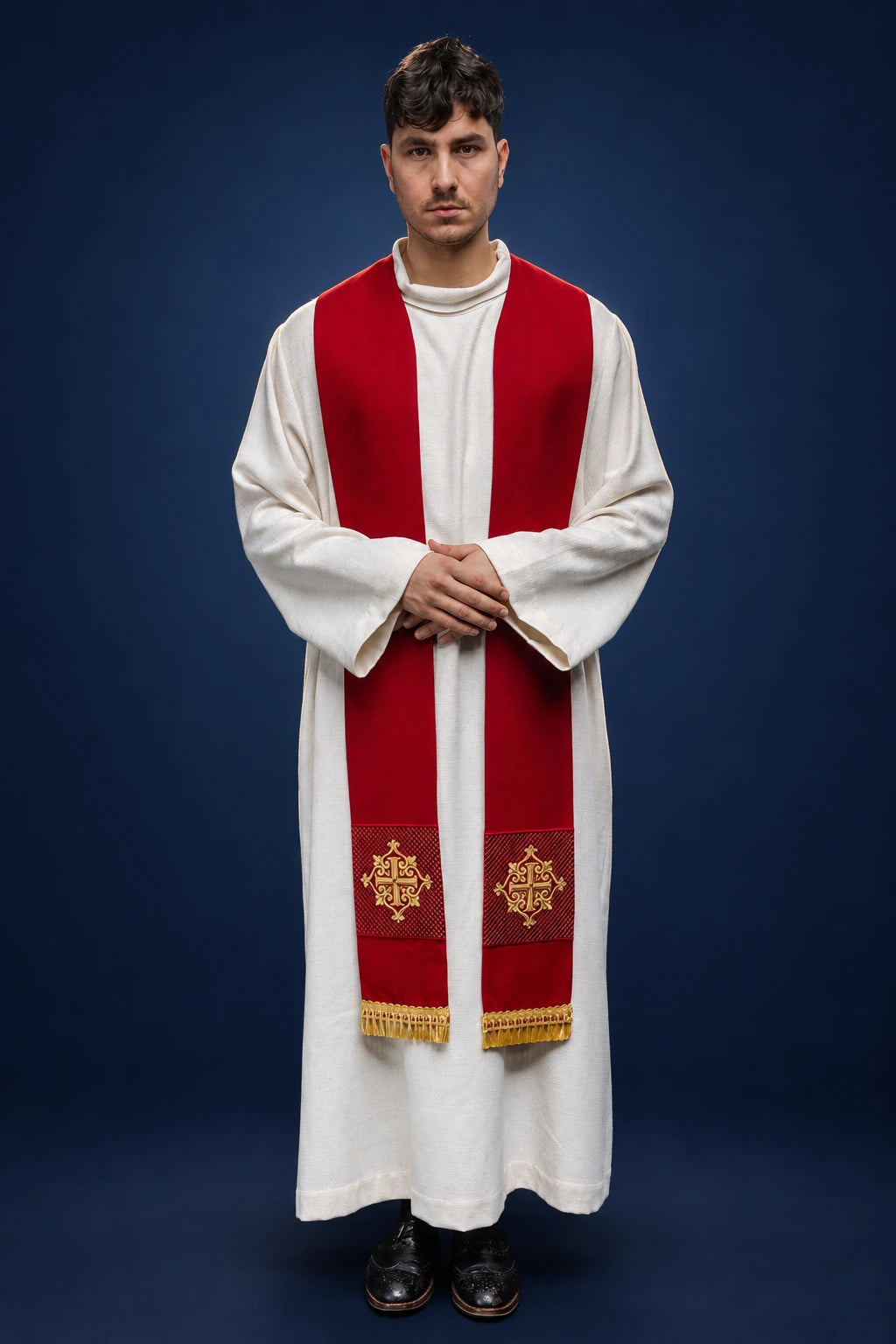 Front view of a red velvet stole worn over white vestments, with gold embroidered cross motifs and fringe ends