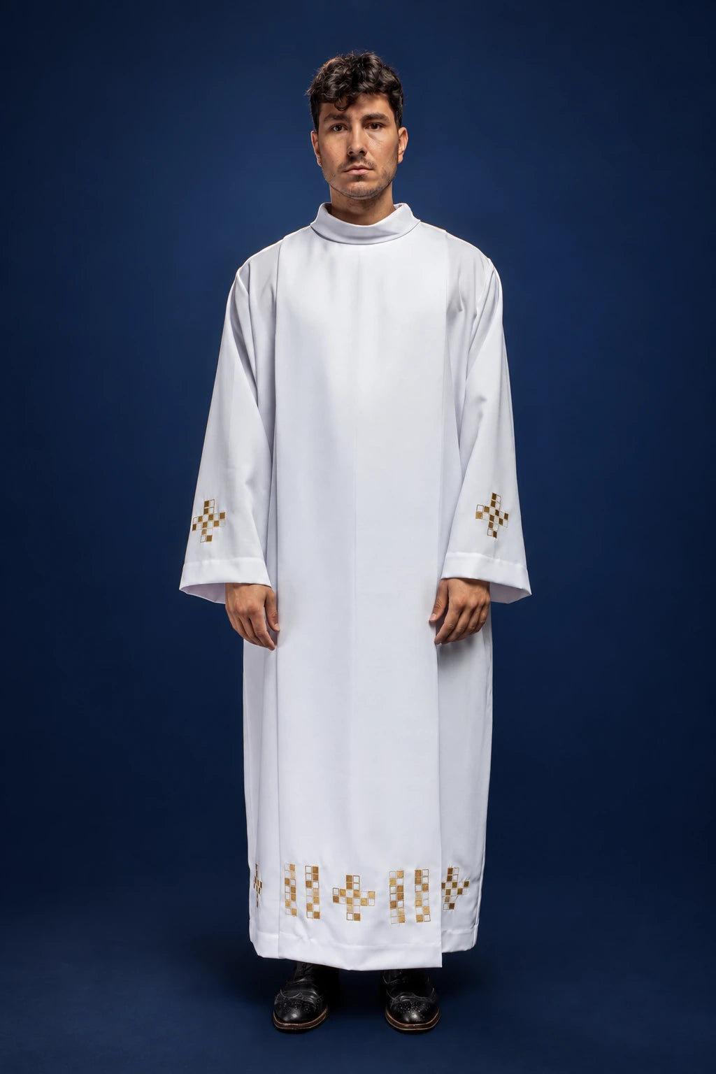 Front view of a white alb with mosaic cross embroidery on the sleeves and hem