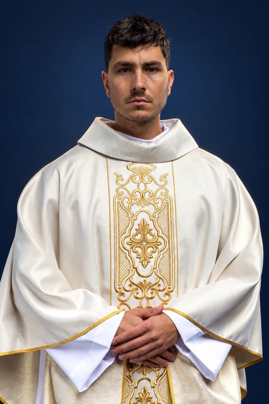 Front view of a white chasuble with gold embroidered orphrey and gold-trimmed sleeves