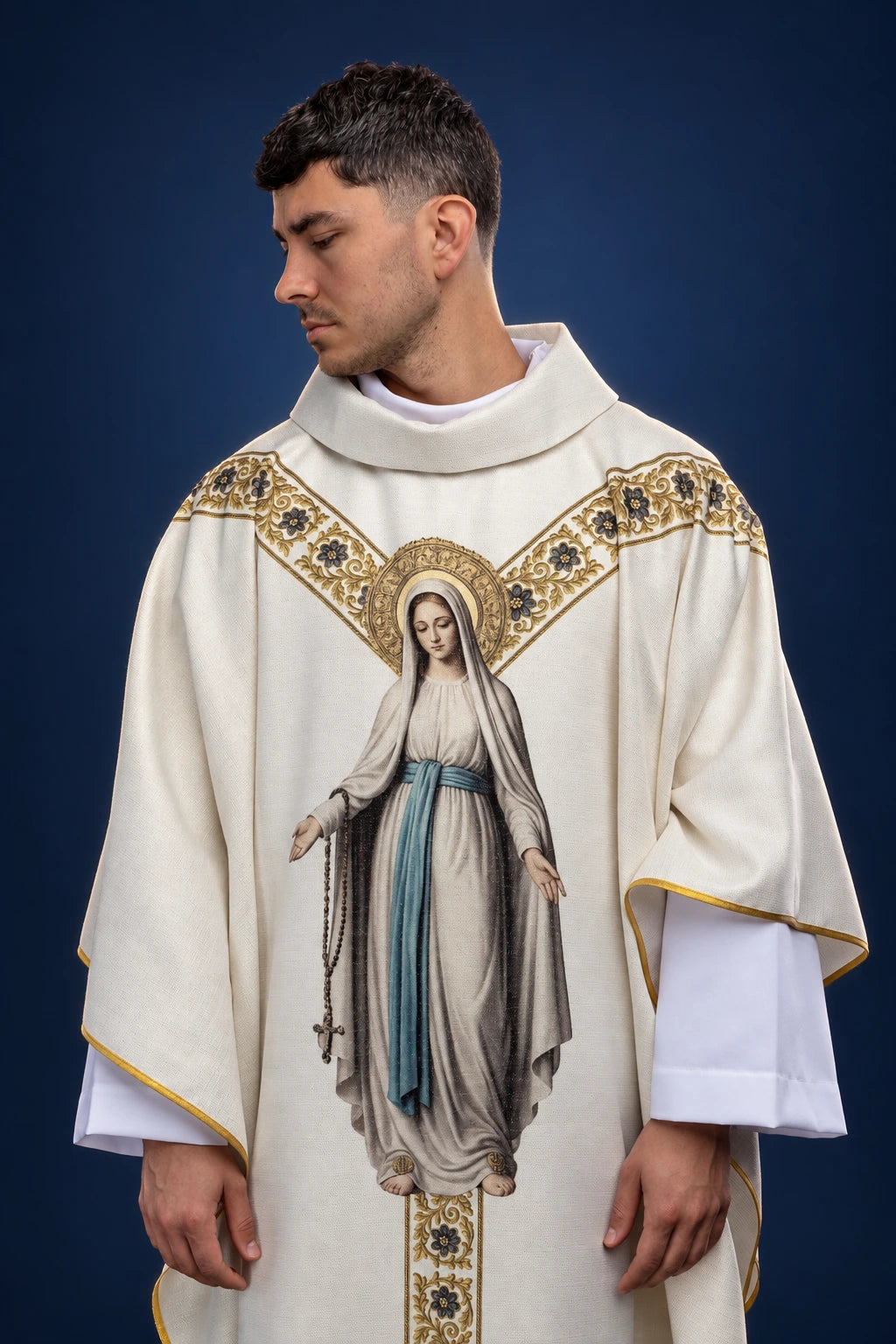 Front view of a white chasuble with gold Marian trim and a large Our Lady of Lourdes print on the front