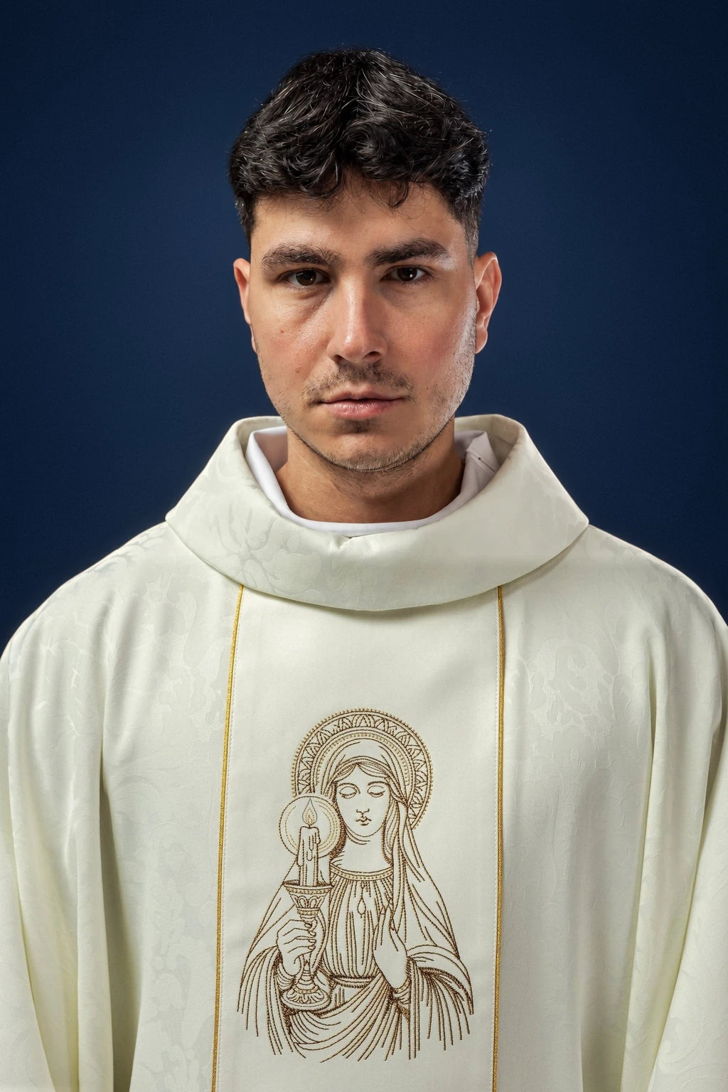 Front view of a white chasuble with gold piping and an embroidered Our Lady of Candlemas image on the chest