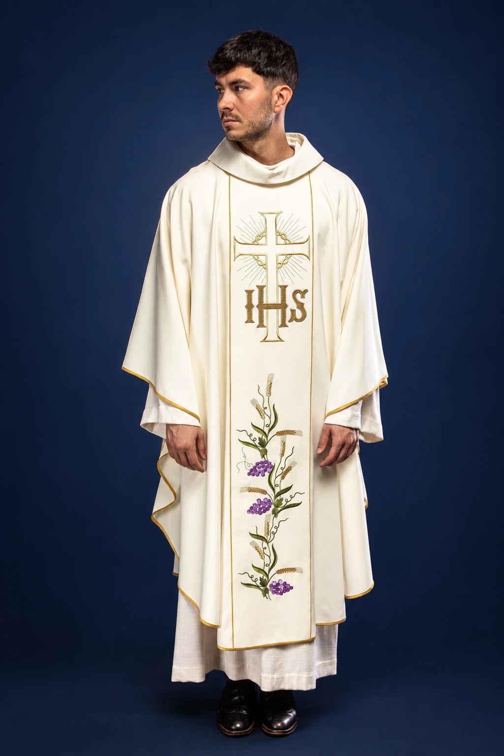Front view of a white chasuble with gold trim, IHS cross, and grape and wheat embroidery