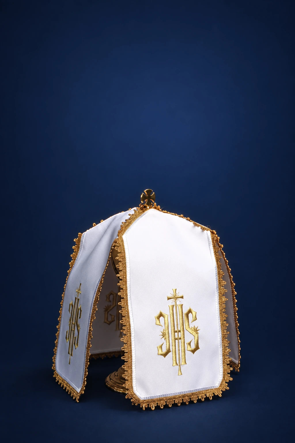Front view of a white ciborium veil with gold trim and gold IHS embroidery