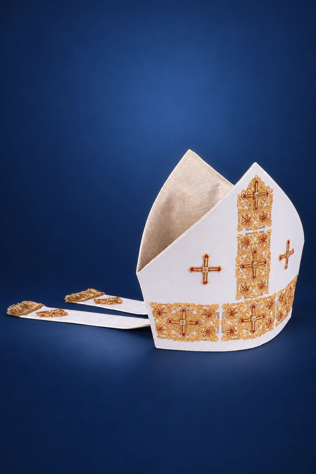 Front view of a white embroidered miter with gold cross motifs and matching gold trim along the base and sides