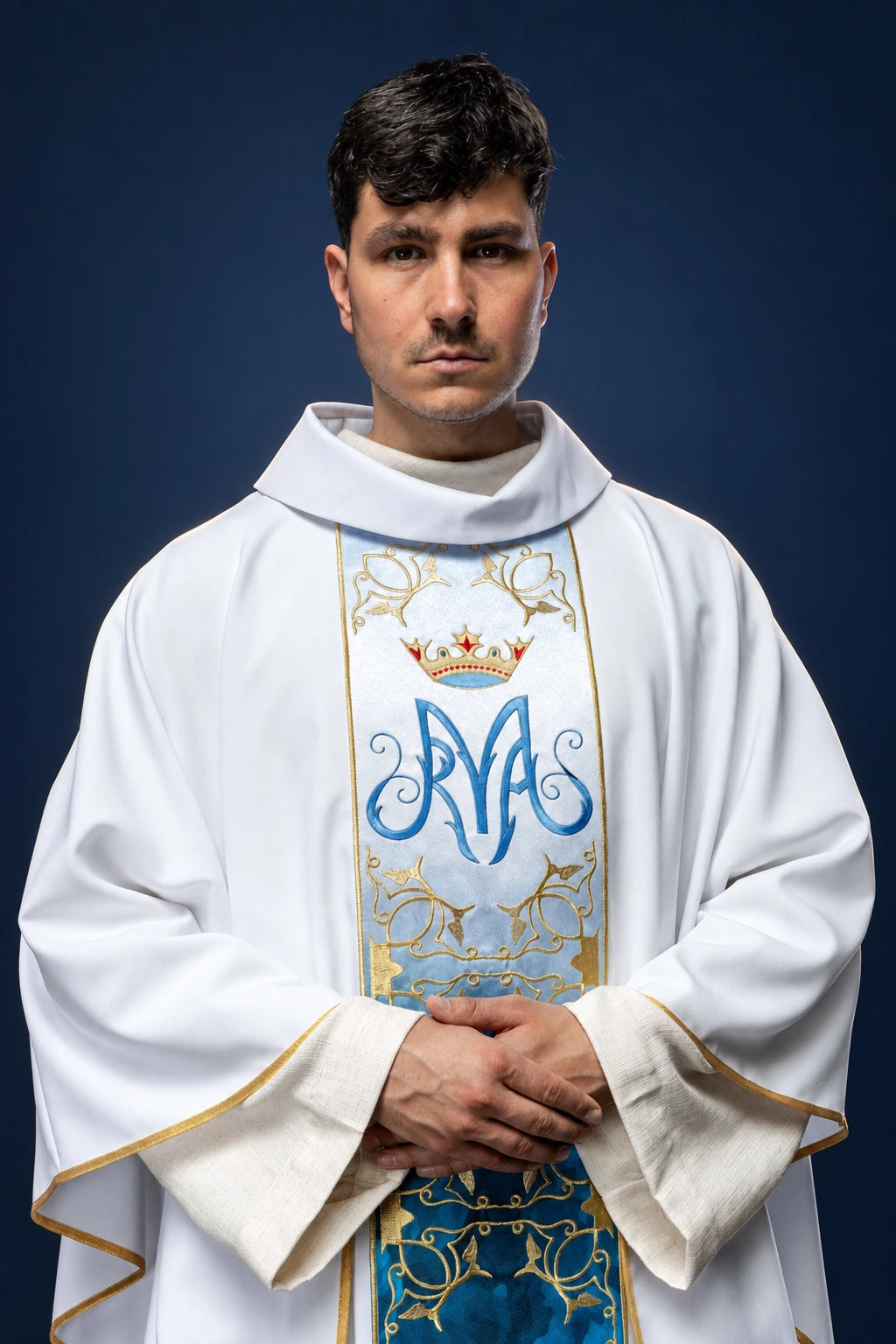 Front view of a white Marian chasuble with blue embroidered orphrey and crowned monogram motif