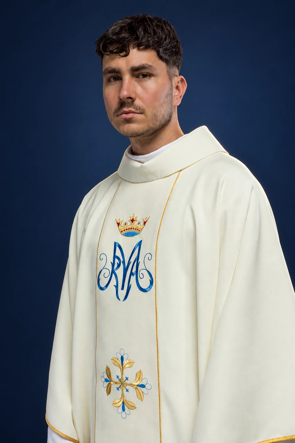 Front view of a white Marian chasuble with gold trim and embroidered blue-and-gold Orphrey cross motif.