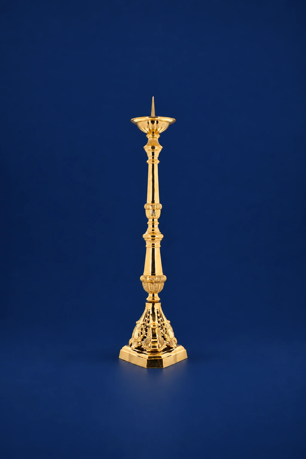 Gold-finished brass candlestick with tall slender stem and ornate base, full view