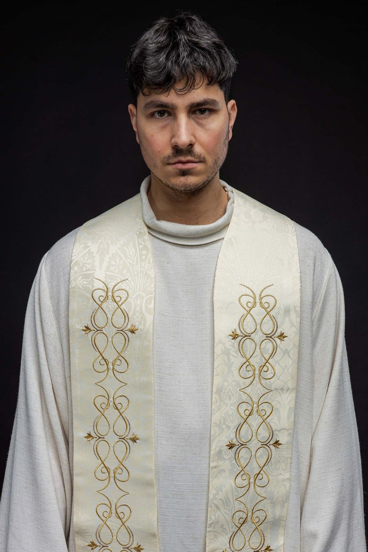 Roman stole close-up showing ecru jacquard fabric and gold embroidery