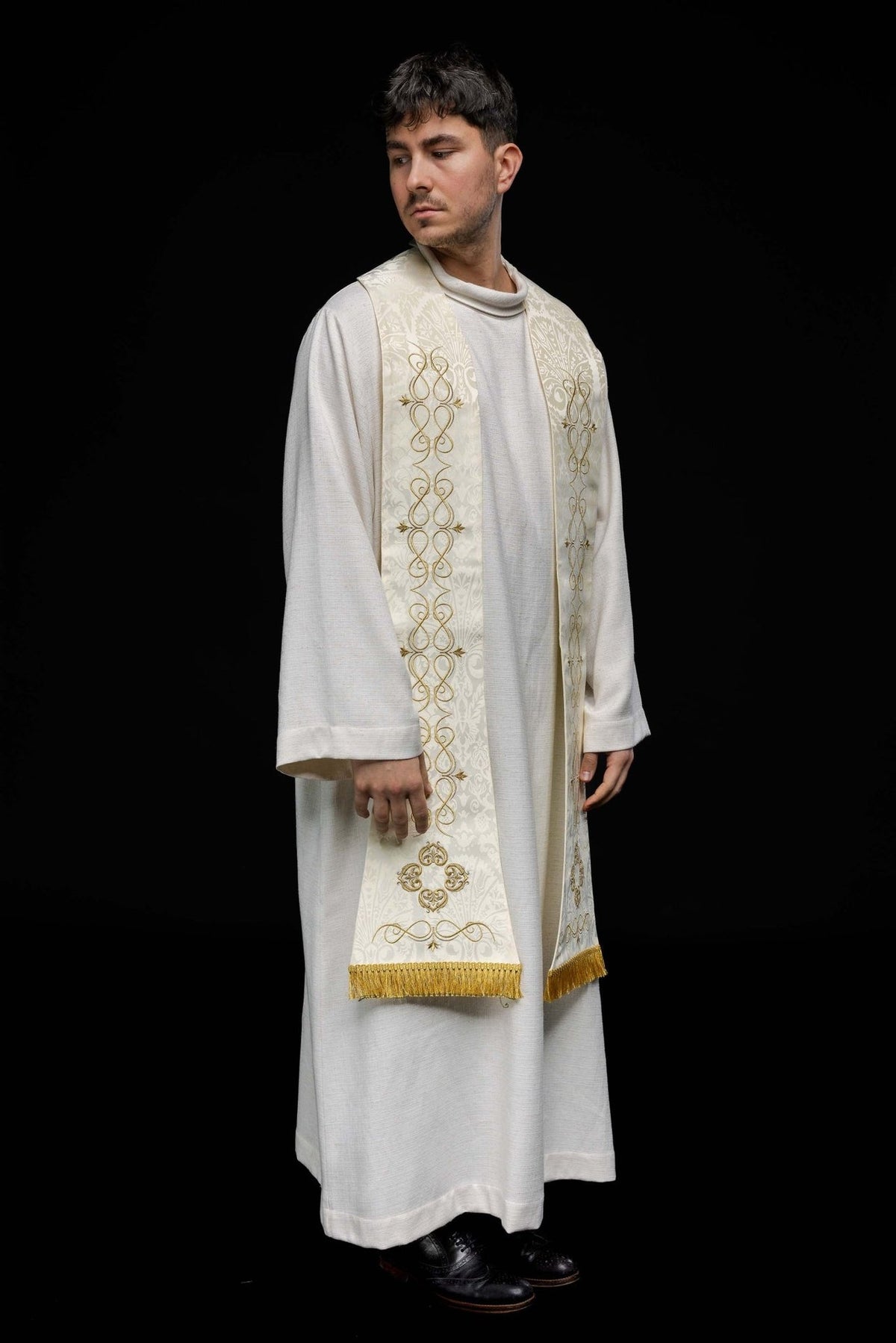 Roman stole worn in a three-quarter view with ecru fabric, gold embroidery and fringe