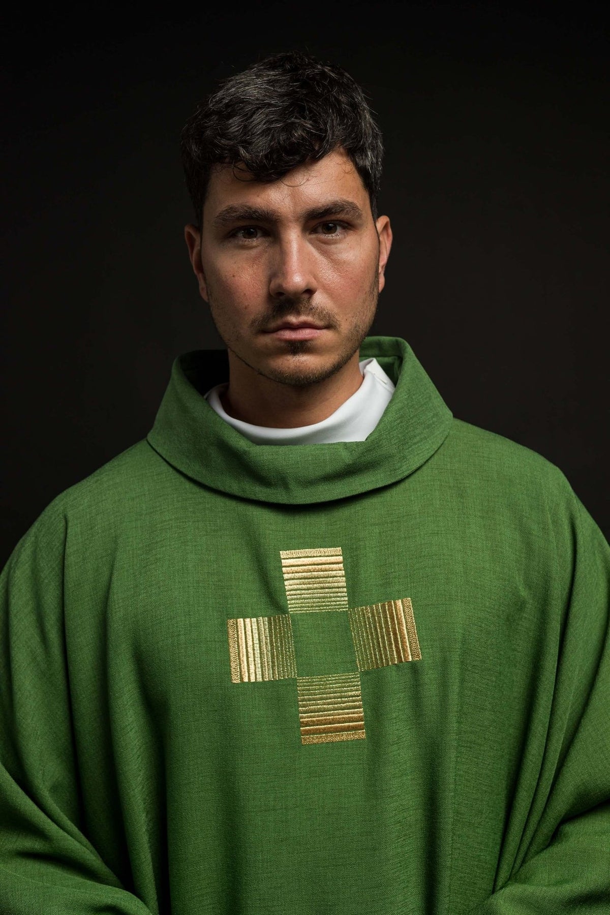 Green chasuble close-up showing a gold embroidered cross and stand-up collar