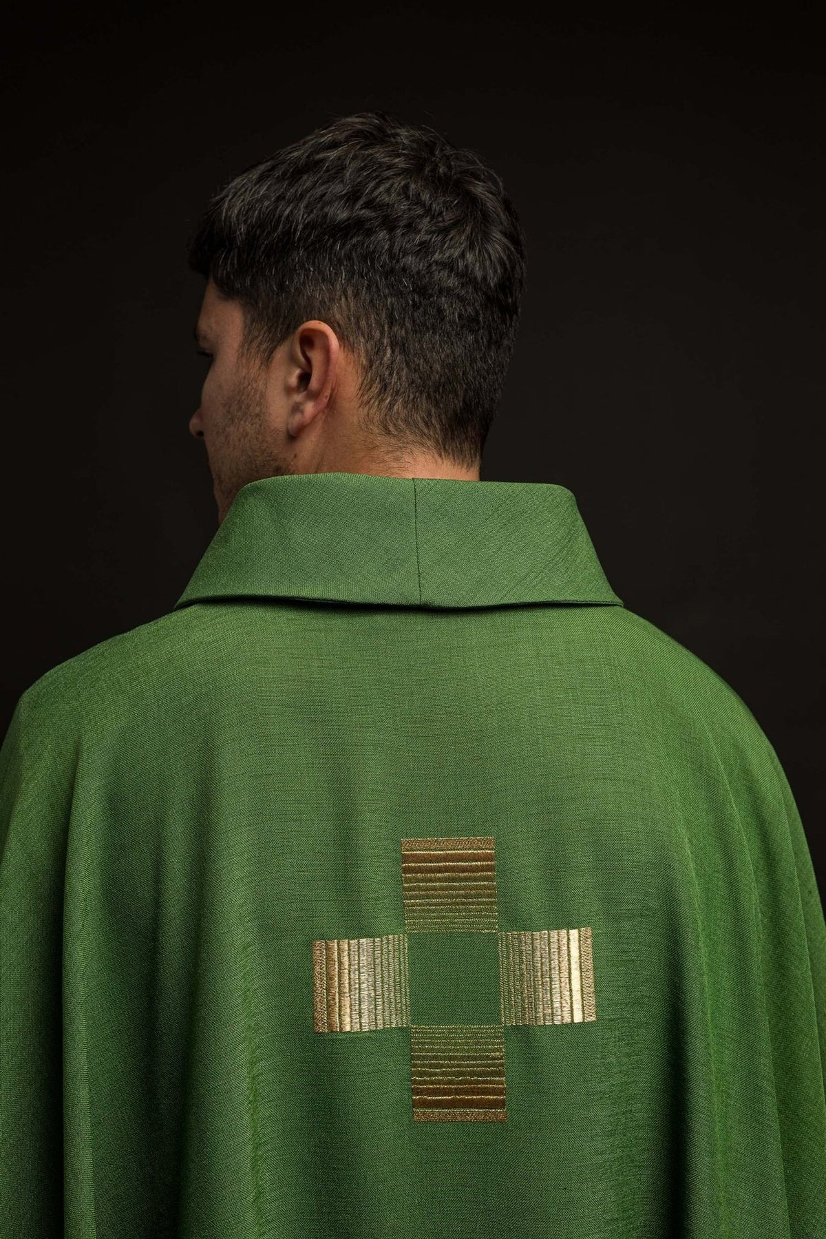 Green chasuble back view showing a gold embroidered cross