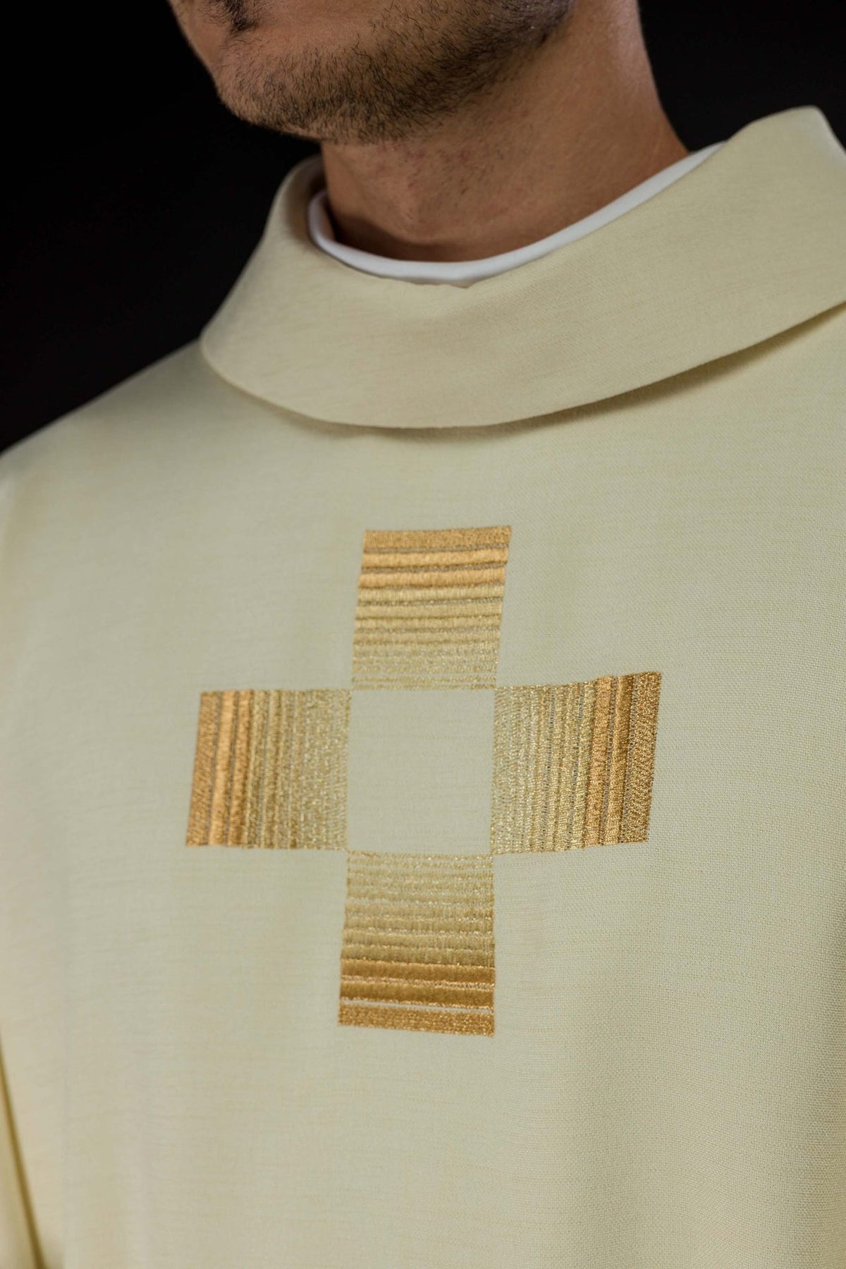 Ivory chasuble close-up showing stand-up collar and embroidered gold cross