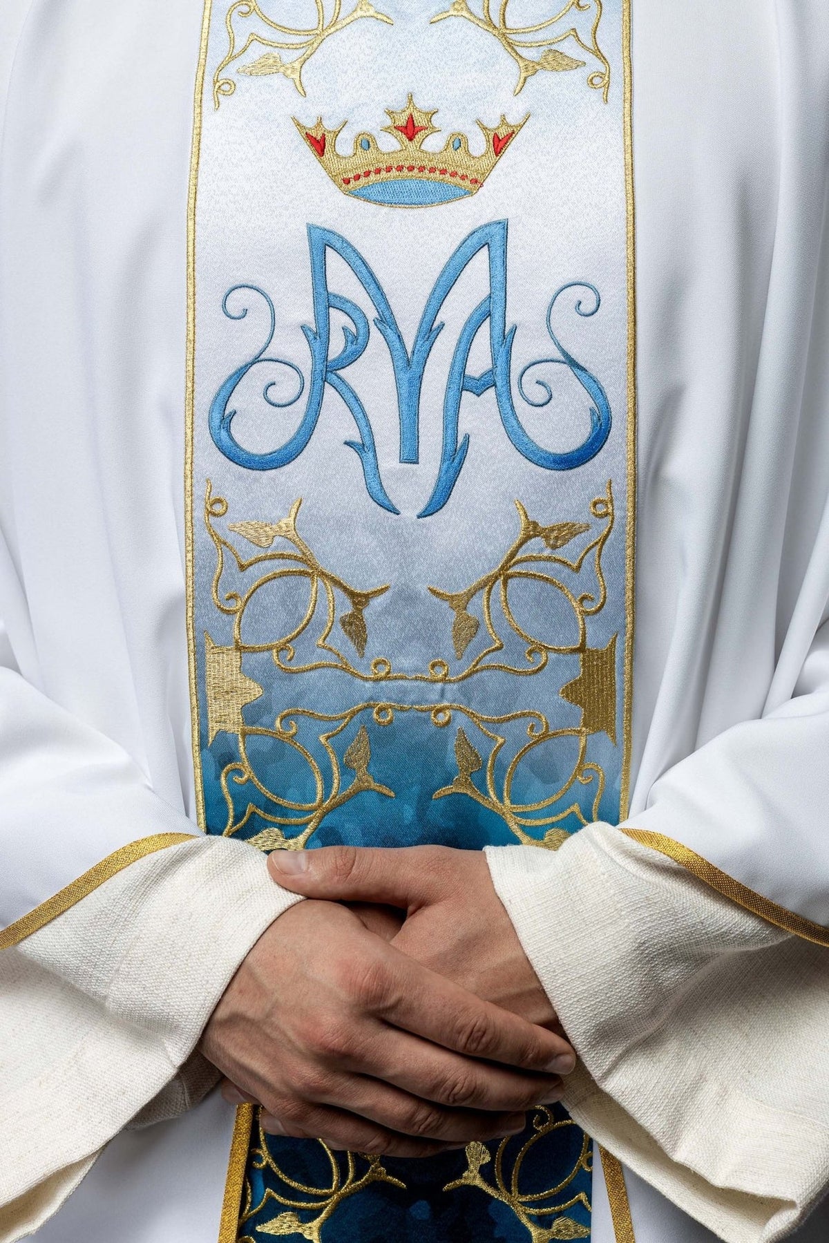 Marian chasuble close-up showing embroidered blue Marian symbol, crown and gold floral trim