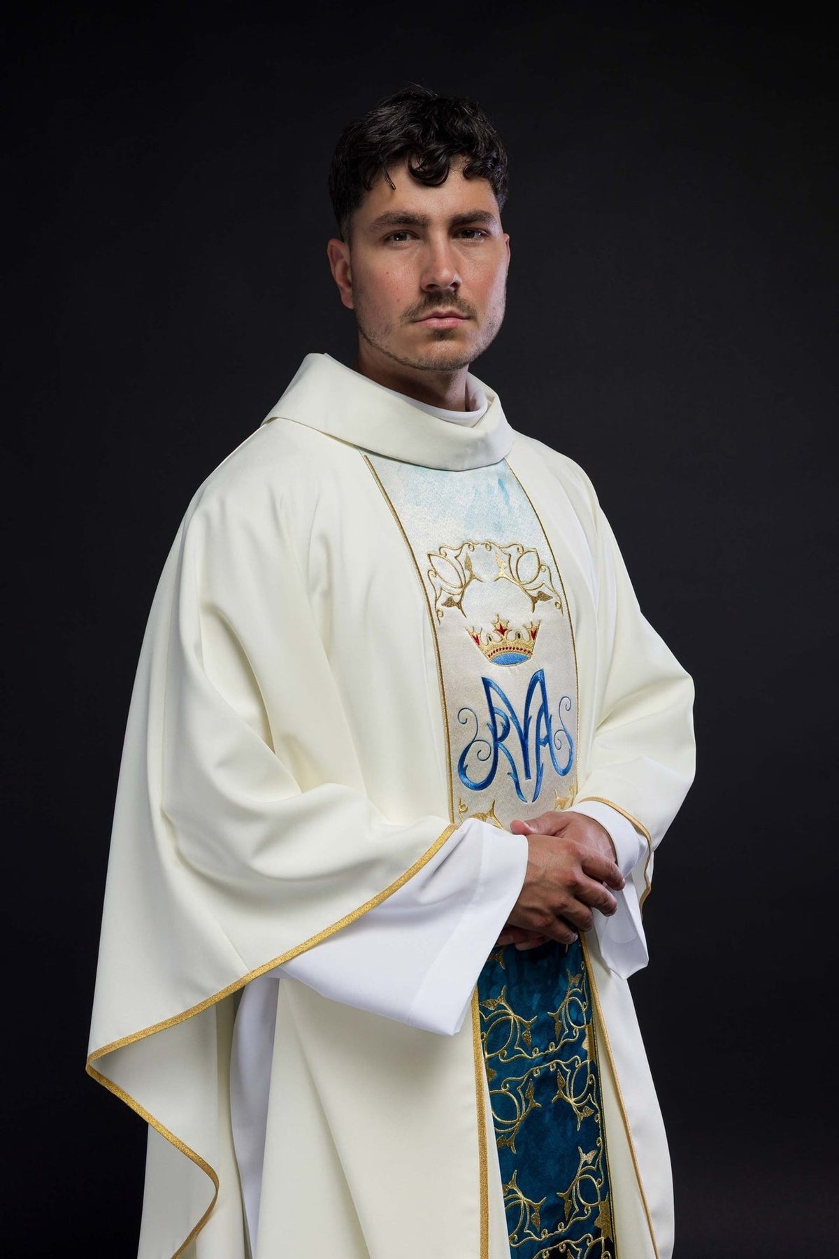 Ecru liturgical chasuble worn from a side angle, showing stand-up collar and embroidered orphrey