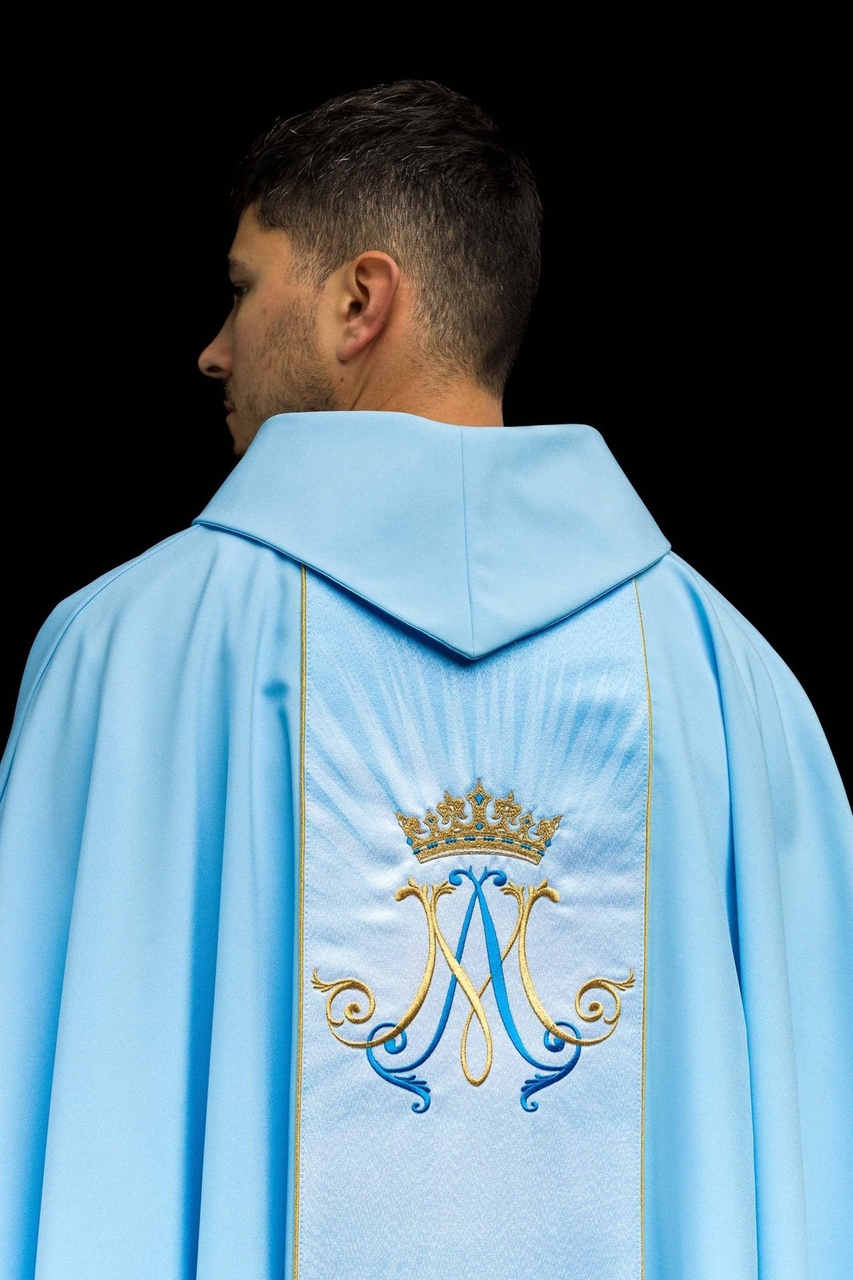 Blue Marian chasuble back view with crowned Marian symbol and gold-edged orphrey