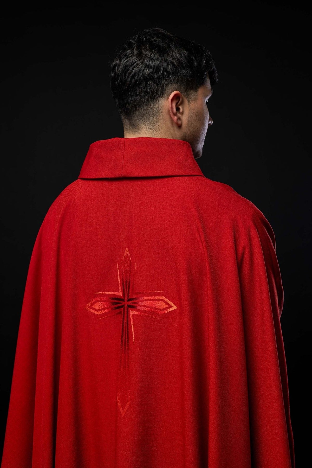 Red chasuble close-up showing satin trim at the sleeve edge