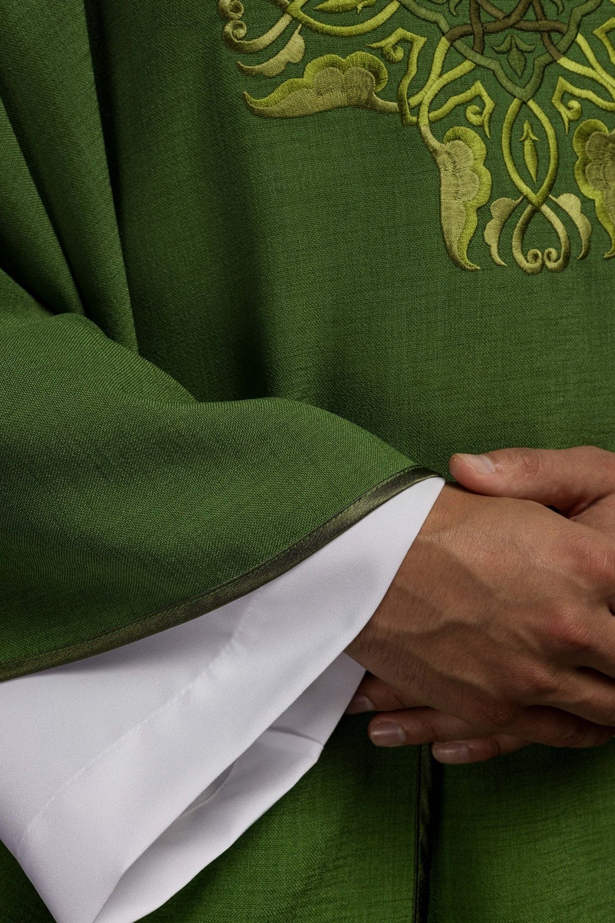 Green chasuble detail showing woven fabric and gold trim