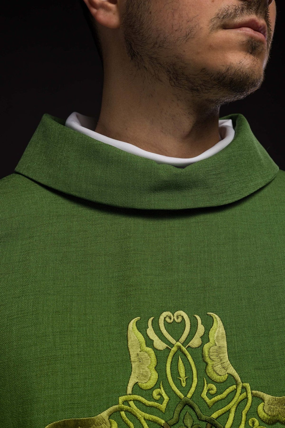 Green chasuble close-up showing stand-up collar and cross embroidery