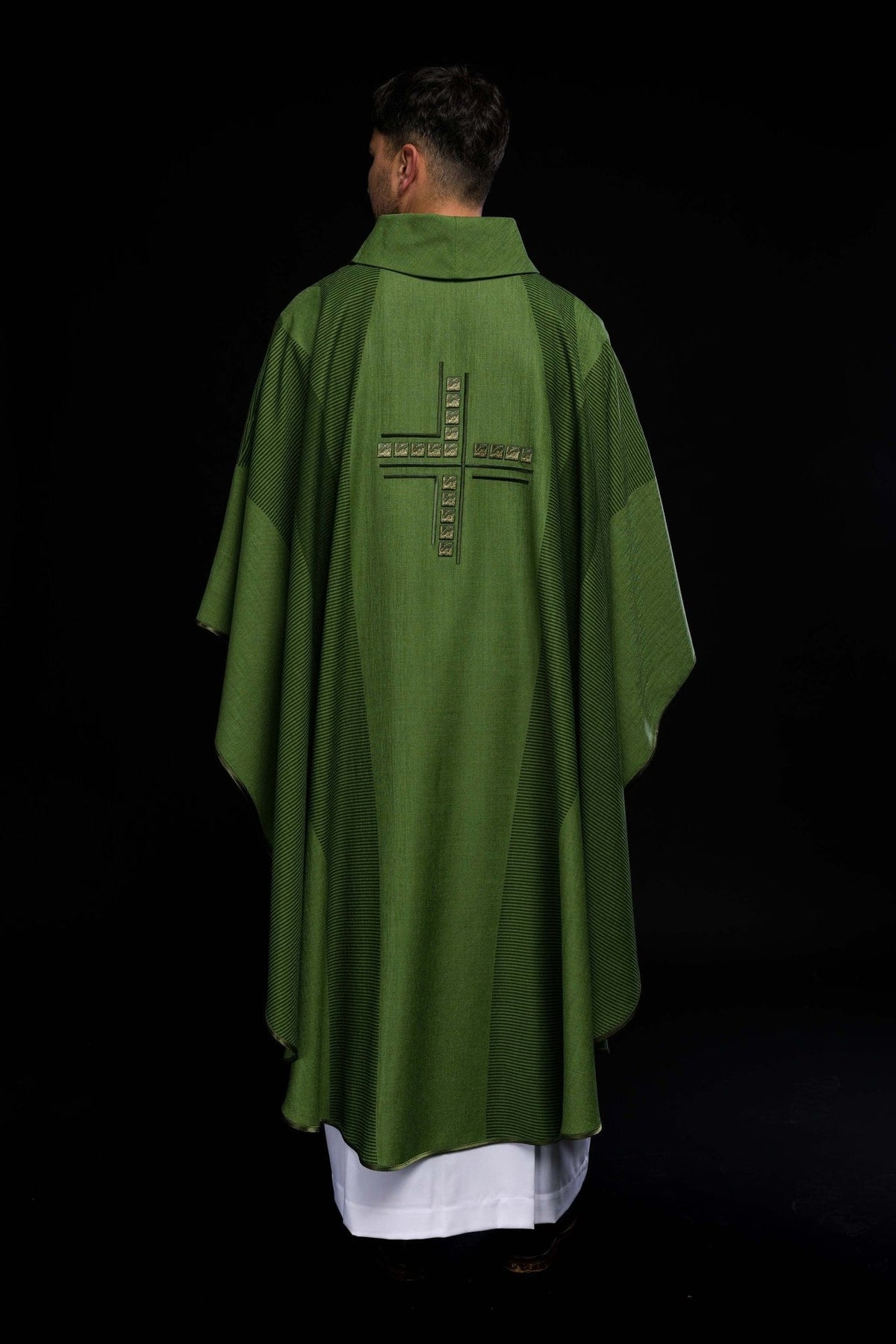 Green chasuble close-up showing dark striped sleeve panels