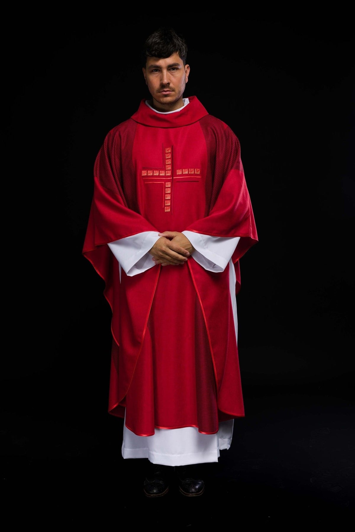 Red chasuble front view worn with embroidered cross and striped trim
