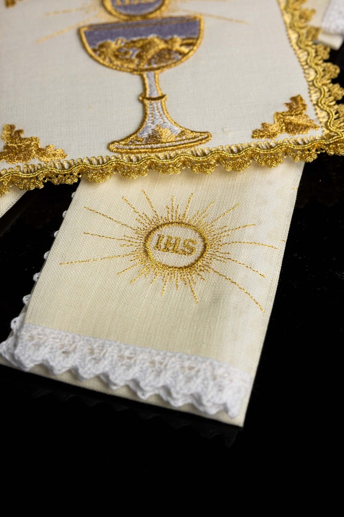 Altar linen set detail showing gold IHS monogram embroidery and white lace edge