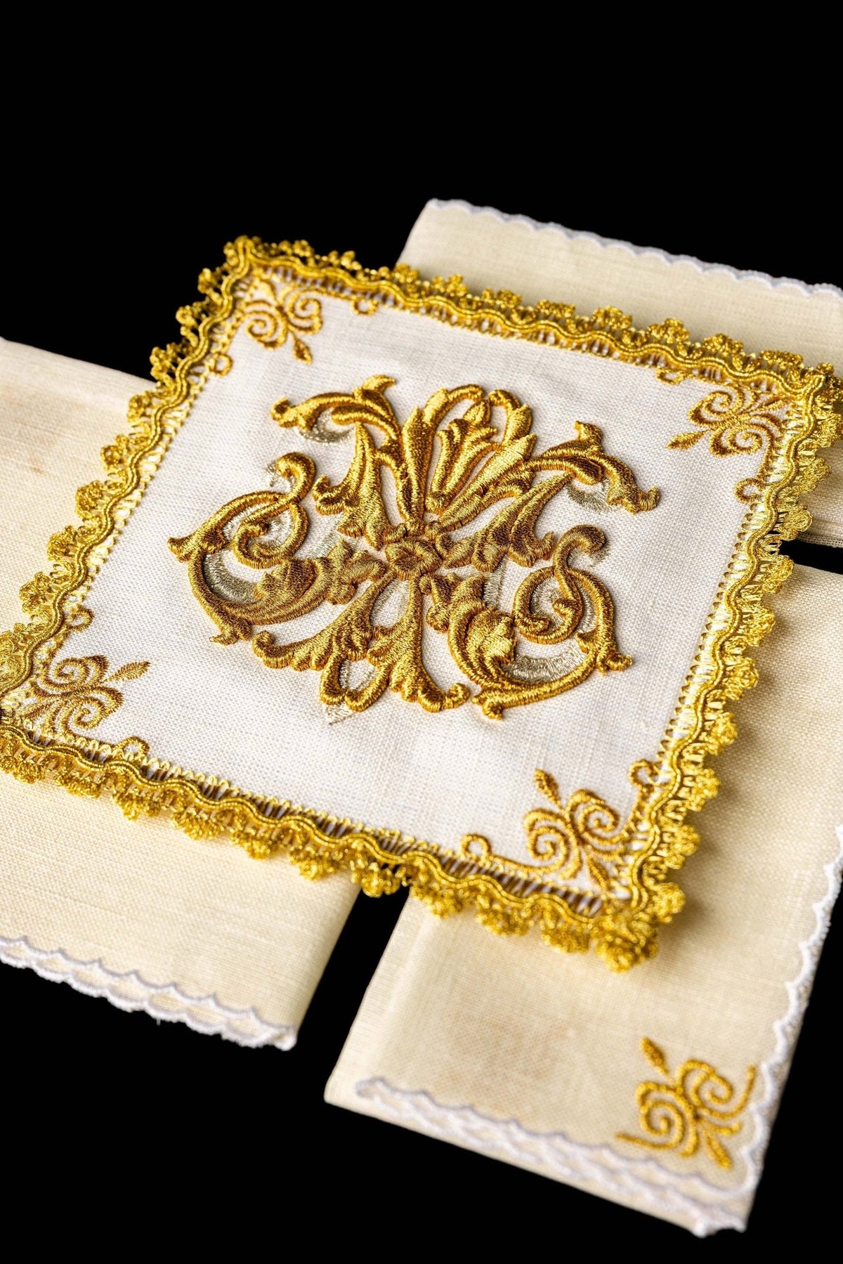 Altar linen set close-up showing central gold embroidery and ornate framed border