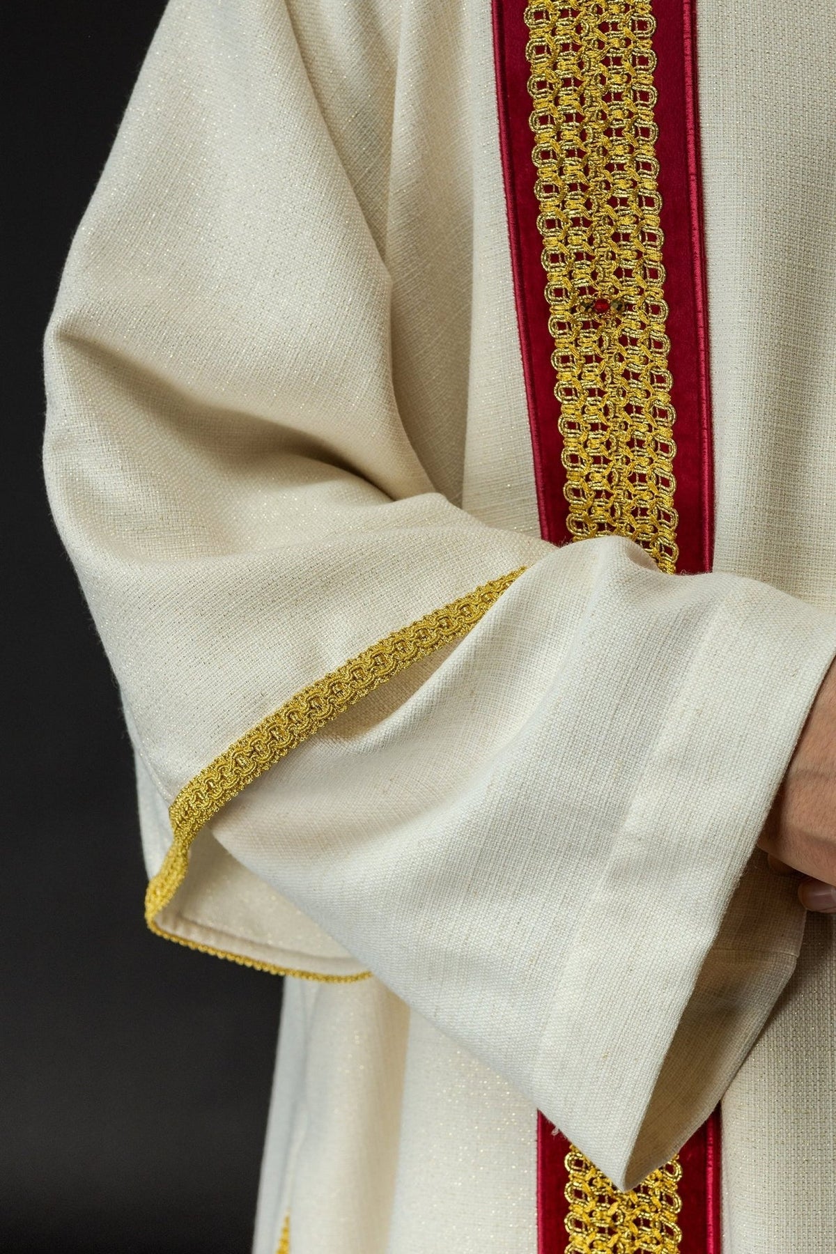 Dalmatic sleeve close-up showing white fabric with gold edging