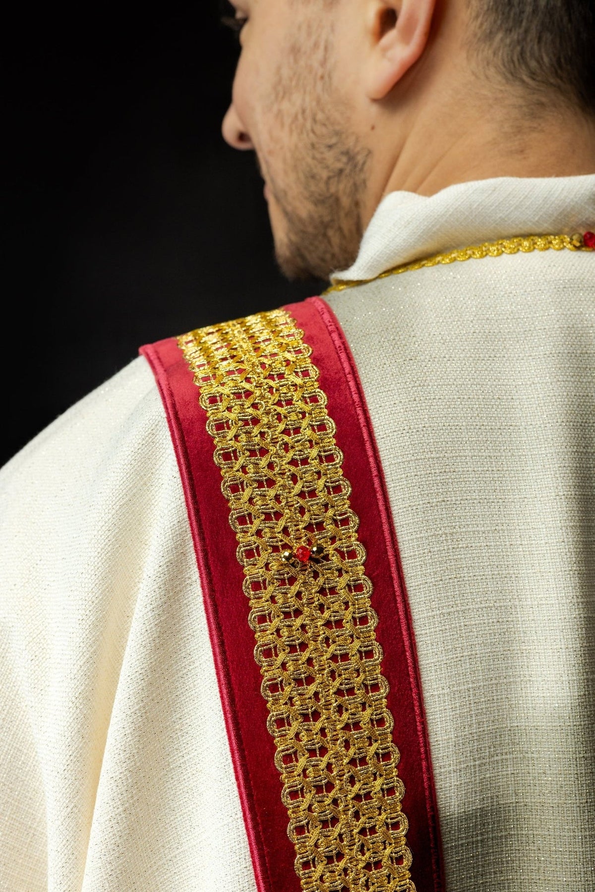 Dalmatic back view showing twin red and gold orphreys on white fabric