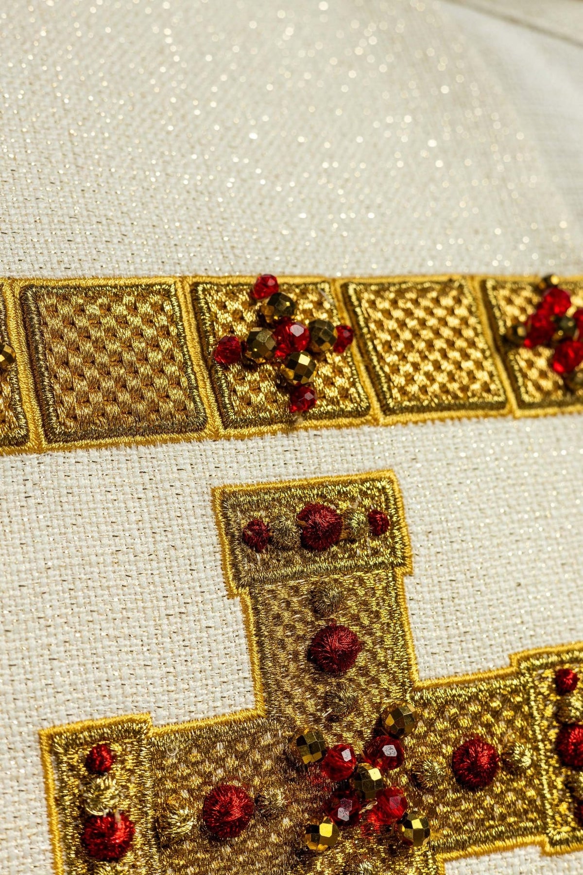 Stole close-up showing gold embroidery and faceted red and brown stones