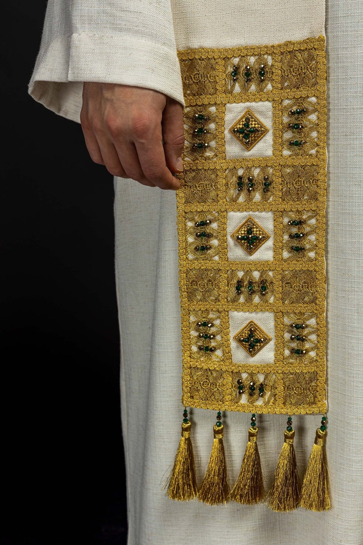 Stole close-up showing gold embroidery, green stones and gold tassel trim
