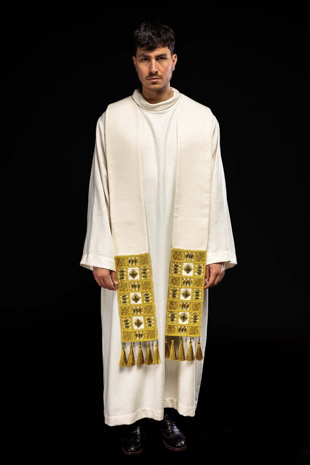 Stole worn front view showing white fabric, gold embroidery and tassels