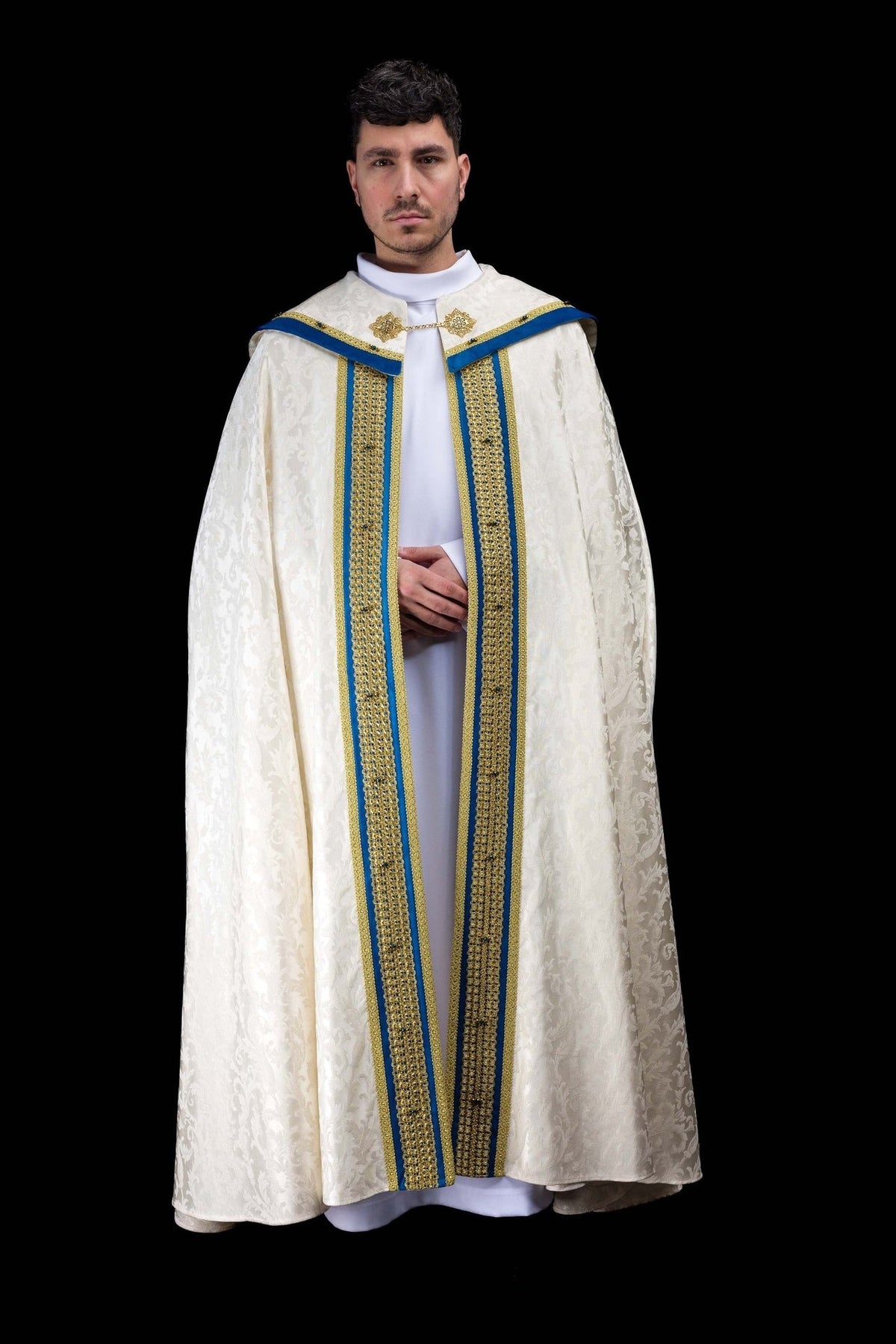 Marian cope front view in ecru jacquard fabric with blue velvet panels and gold embroidery