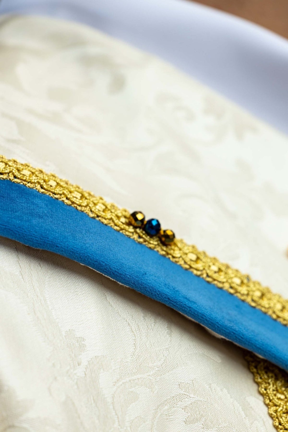 Marian cope detail of blue velvet trim with gold edging and natural stones
