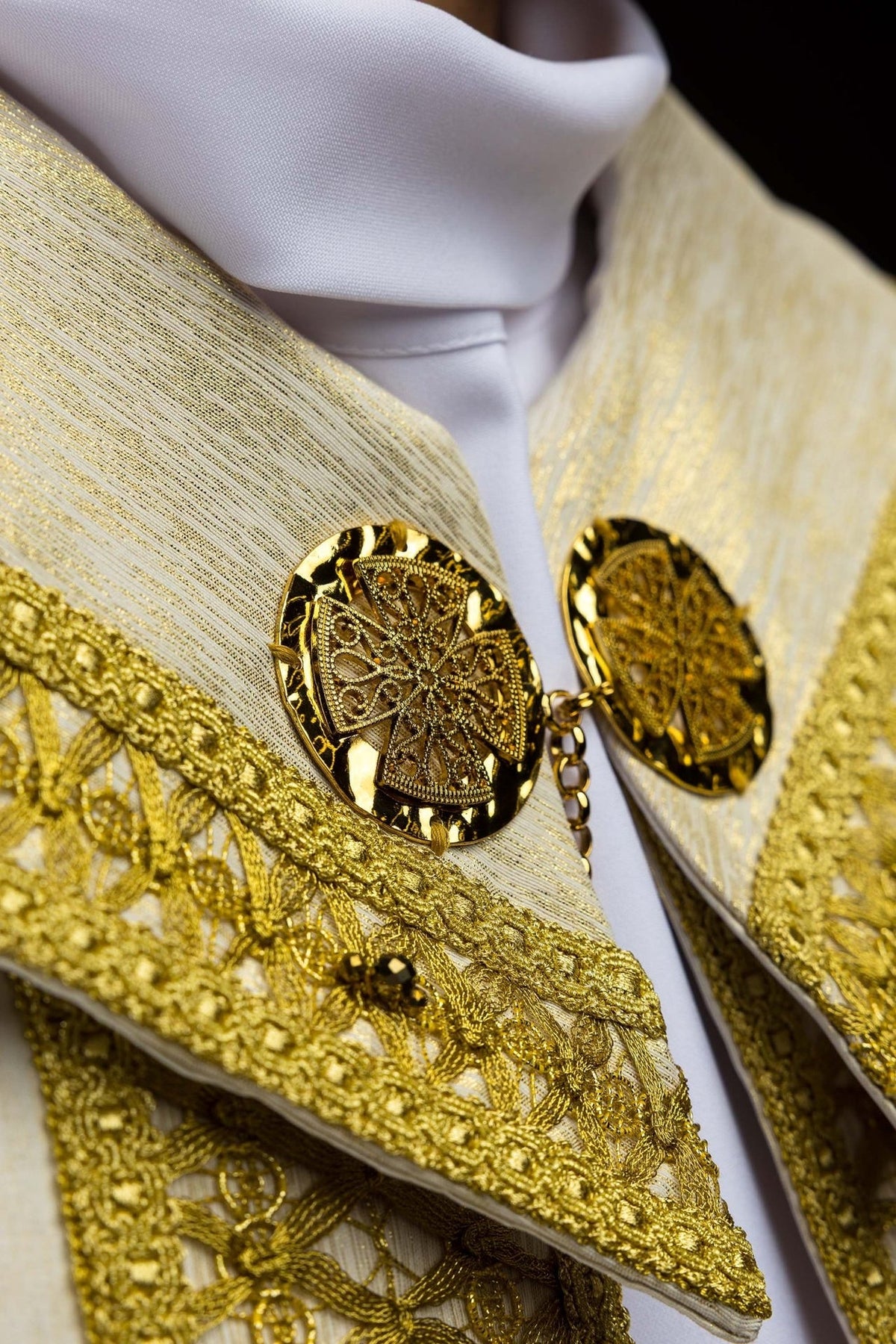 Handcrafted cope clasp and gold embroidery with natural stones, close-up