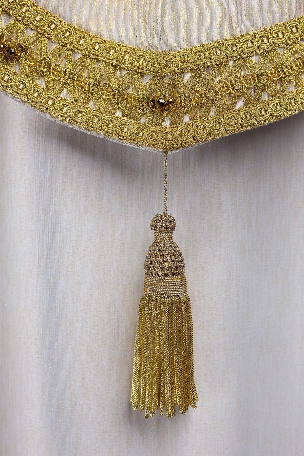 Handcrafted cope gold tassel and embroidered lower trim, close-up