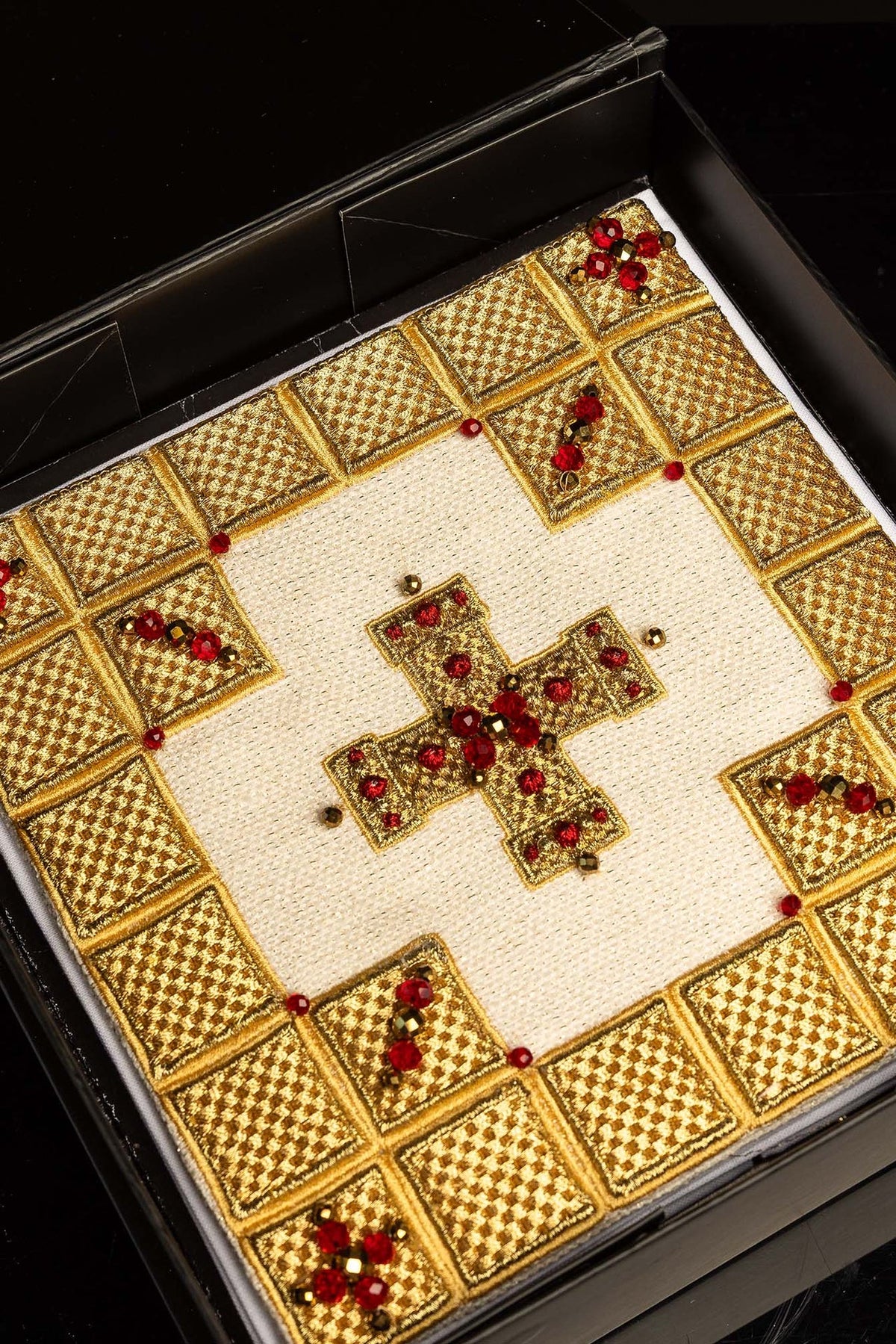 Altar linen set close-up of gold embroidery, cross and red natural stones