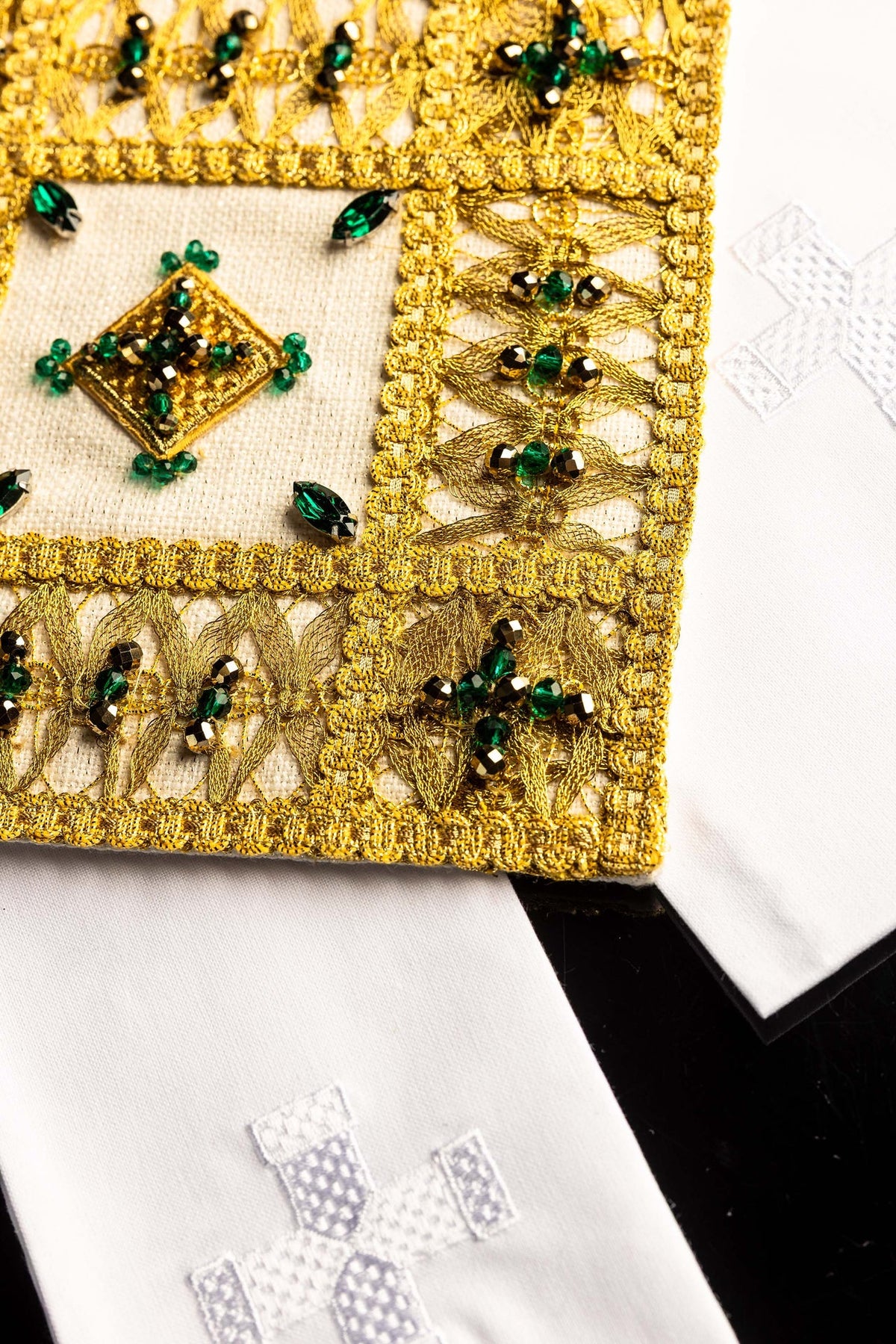 Altar linen set close-up showing gold lattice embroidery, jeweled center, and white linen