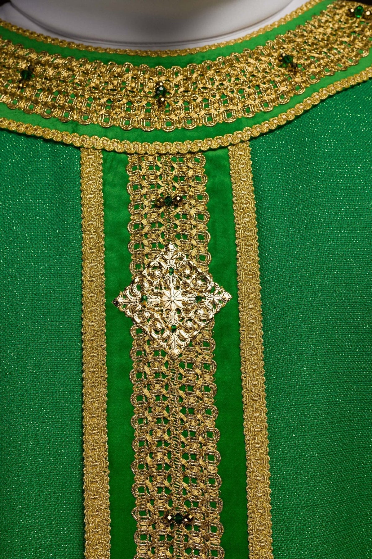Green chasuble orphrey close-up with gold embroidery and natural stones