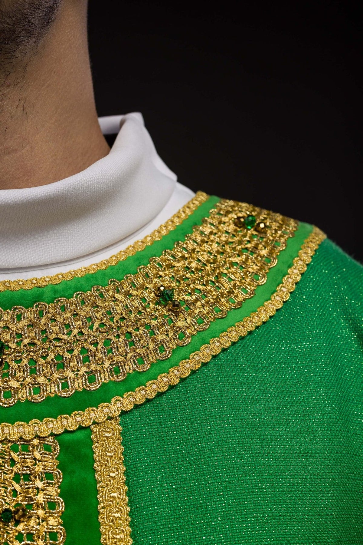 Green chasuble neckline close-up with gold embroidery and green stones