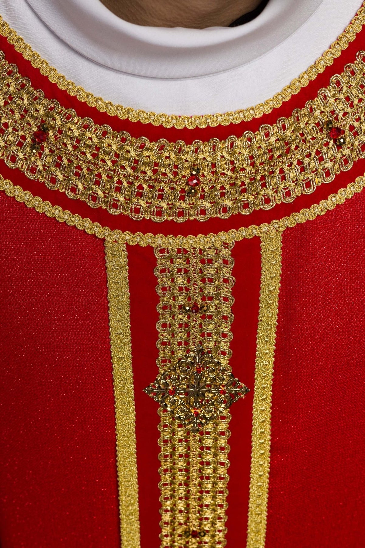 Red chasuble central cross close-up with gold embroidery and red stones