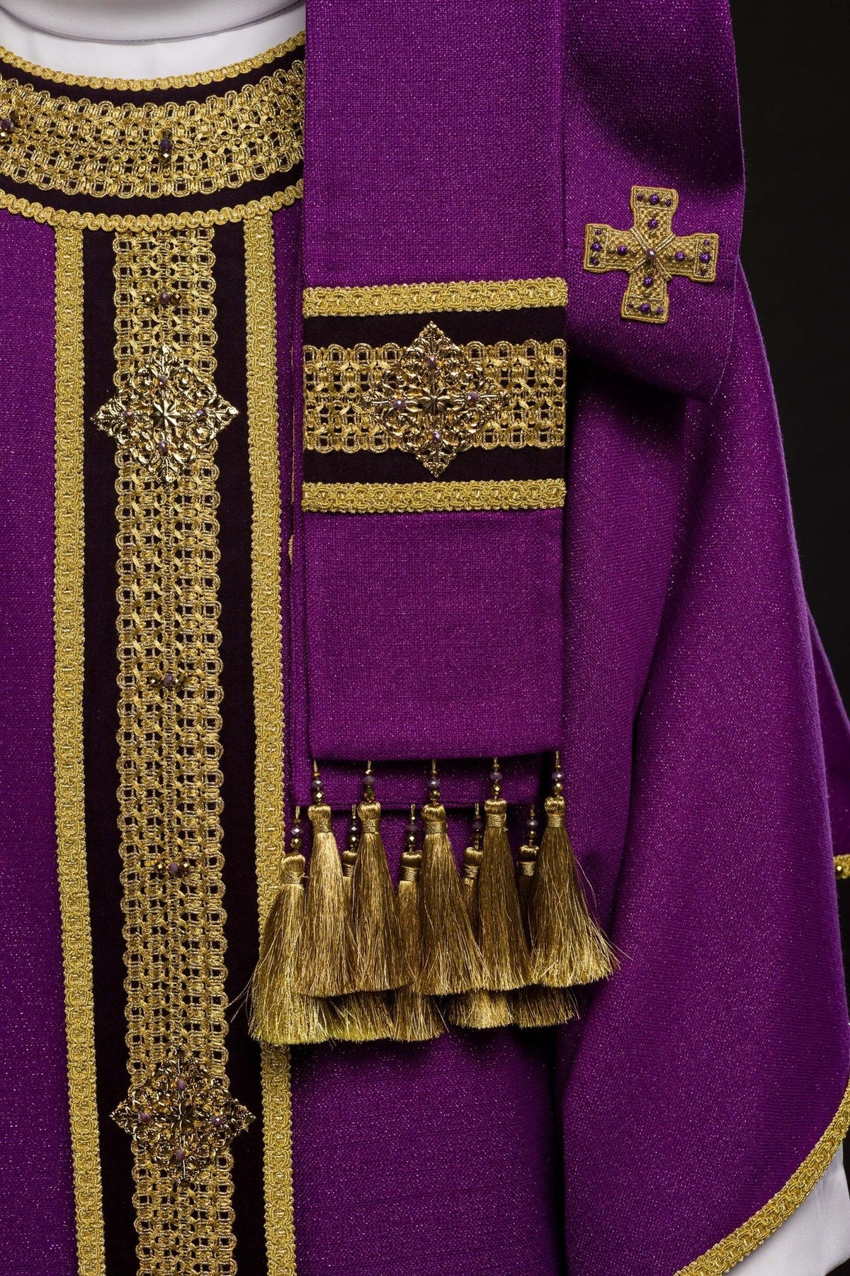 Purple chasuble sleeve detail with gold trim and natural stone accents