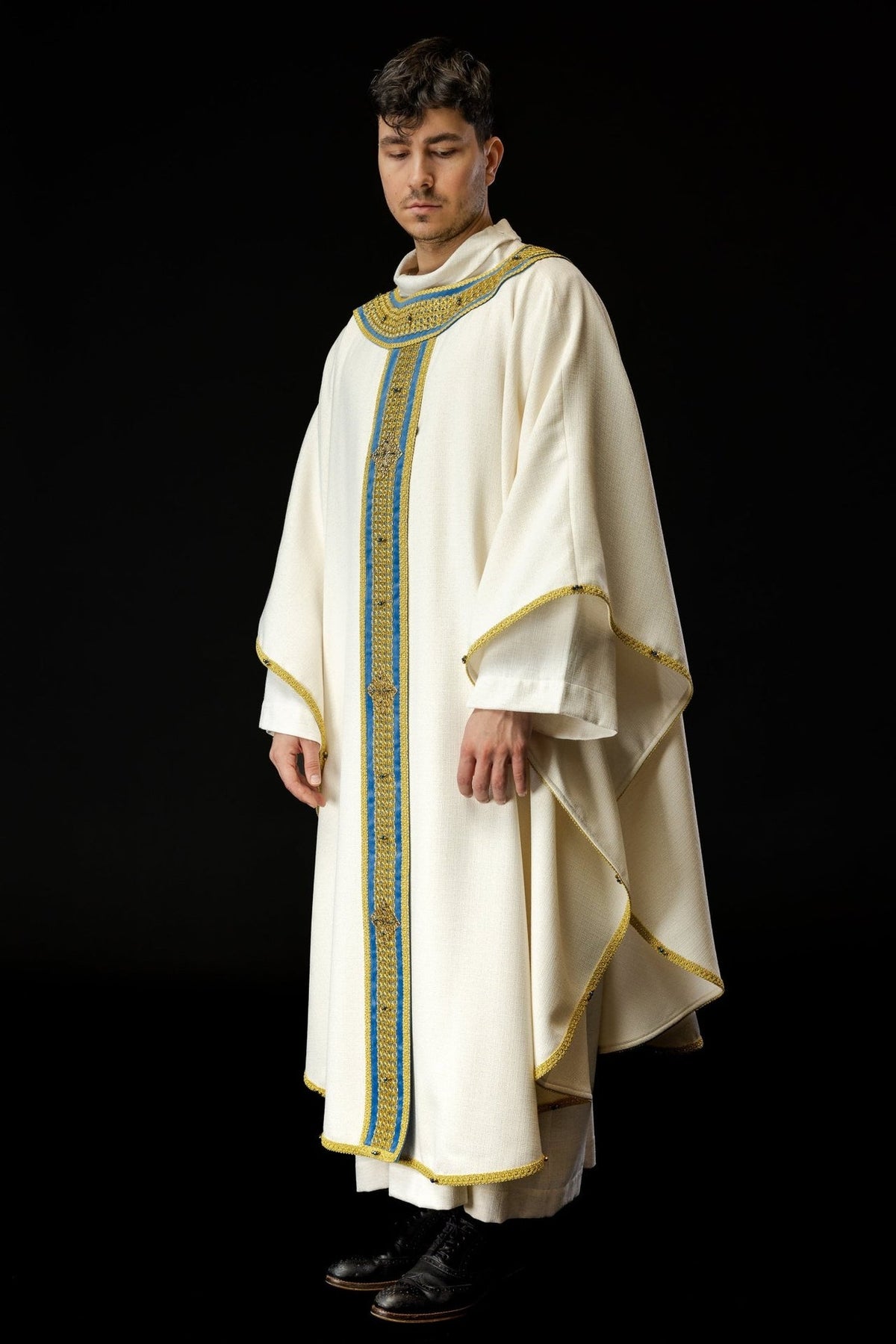 Handcrafted chasuble side view showing wide ivory sleeves, blue orphrey and gold trim