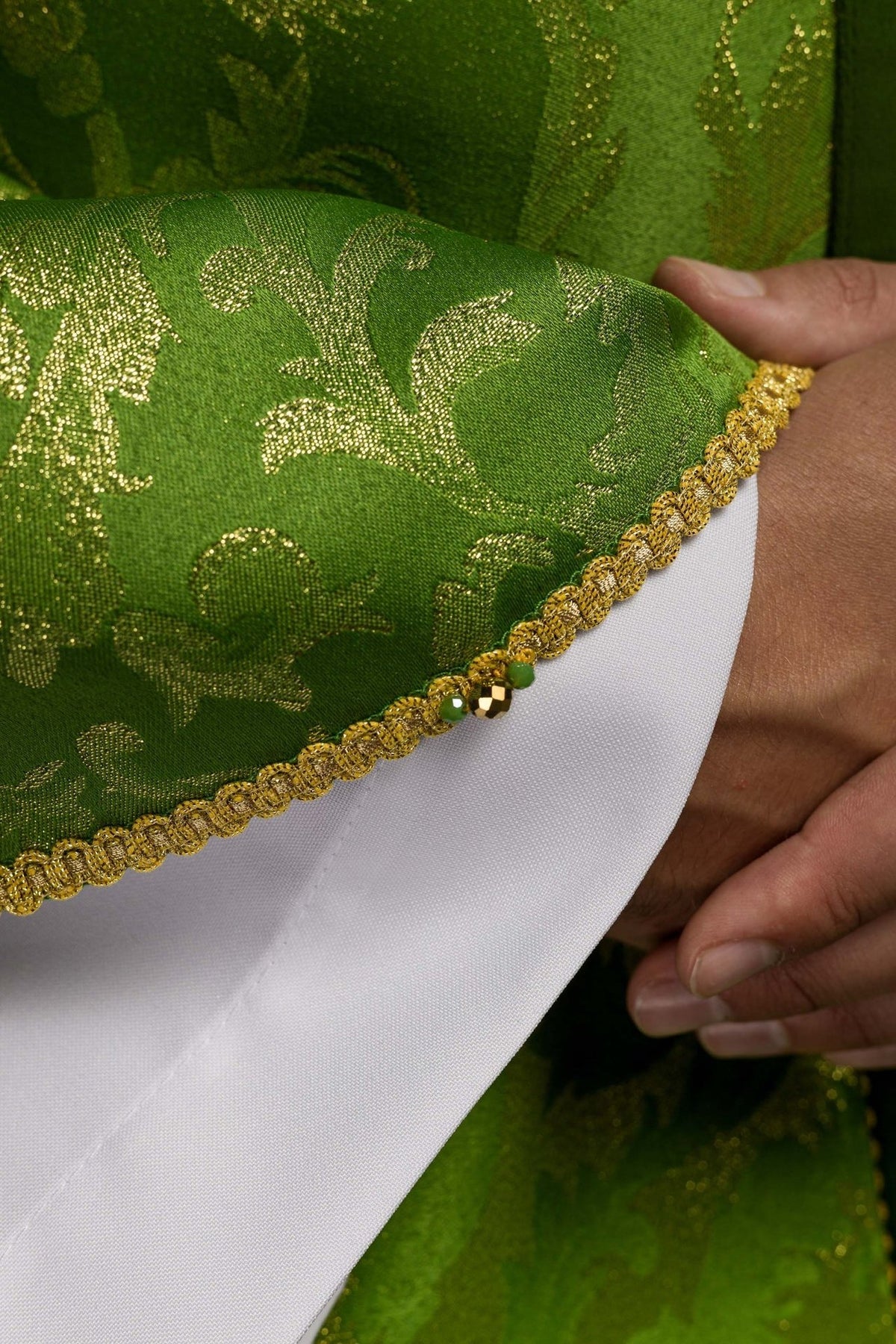 Green chasuble close-up of gold orphrey with green natural stones