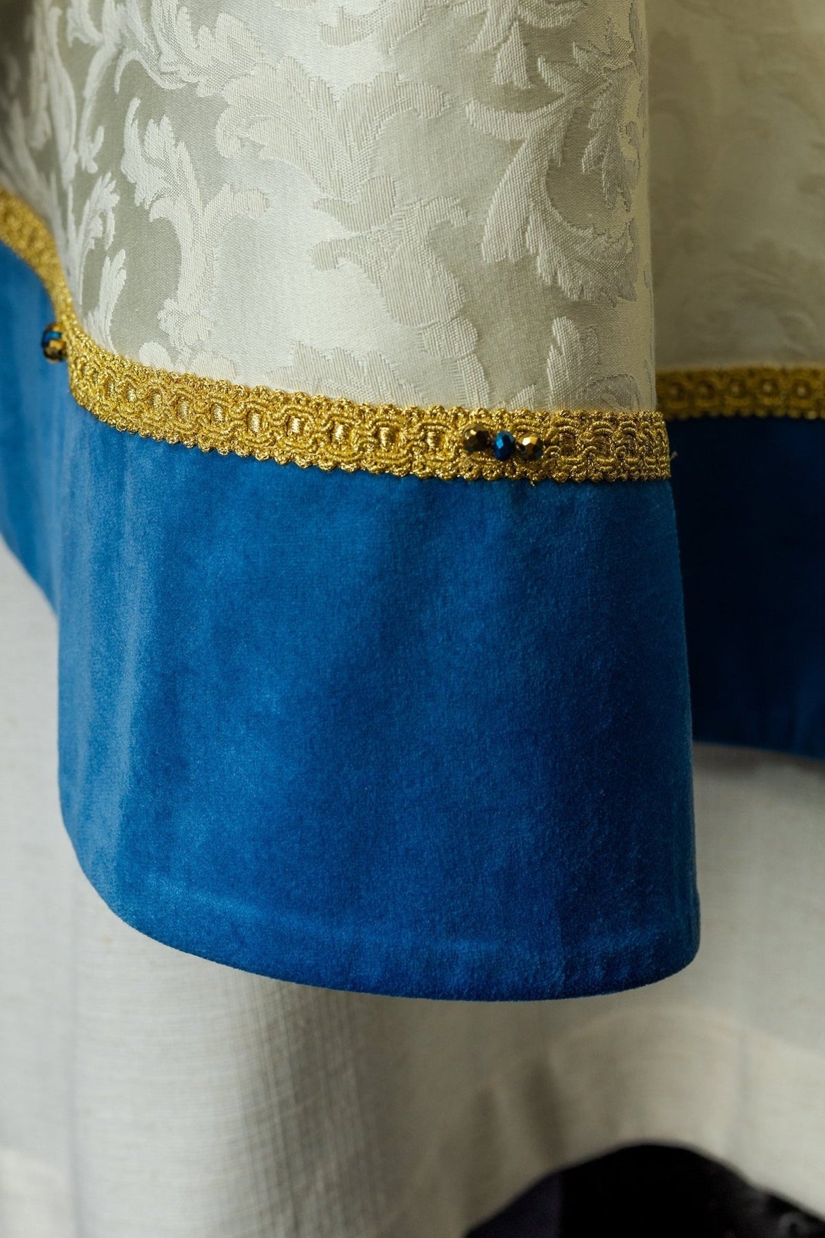 Marian chasuble detail showing blue velvet trim, gold embroidery and natural stones