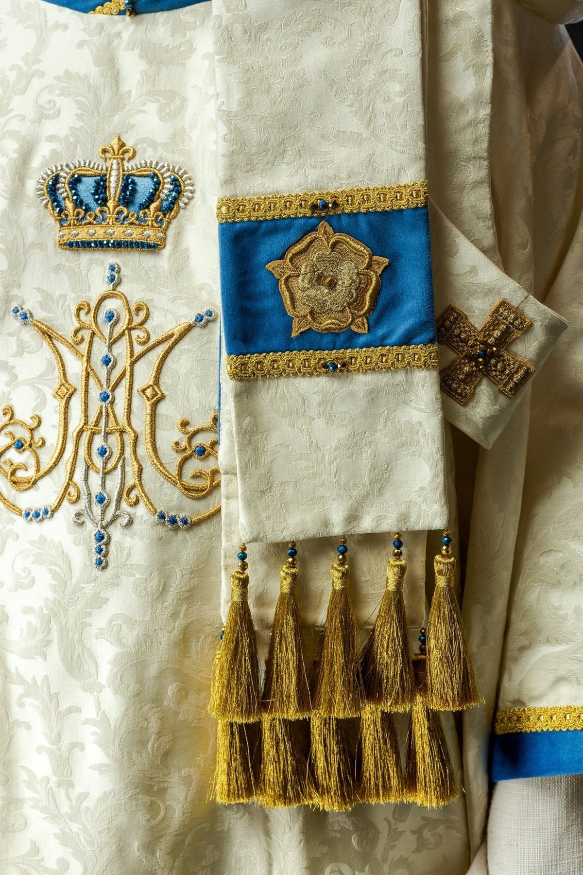 Marian chasuble detail showing embroidered crown and Marian symbol on ivory jacquard fabric